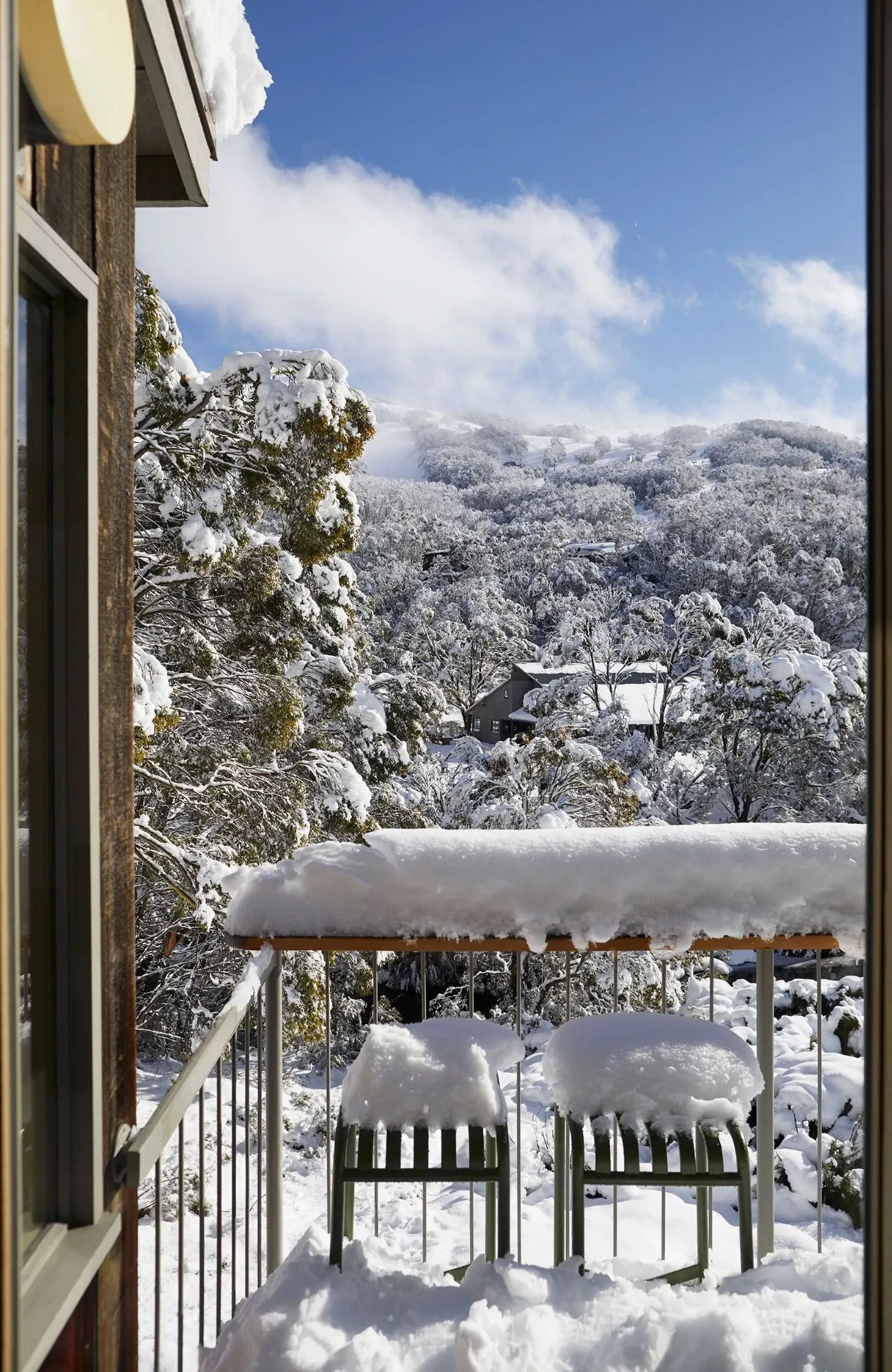 Cedar Cabin by Nicholas Gurney & Monique Easton. Cabin balcony buried in white snow, views out to Mount Kosciuszko.