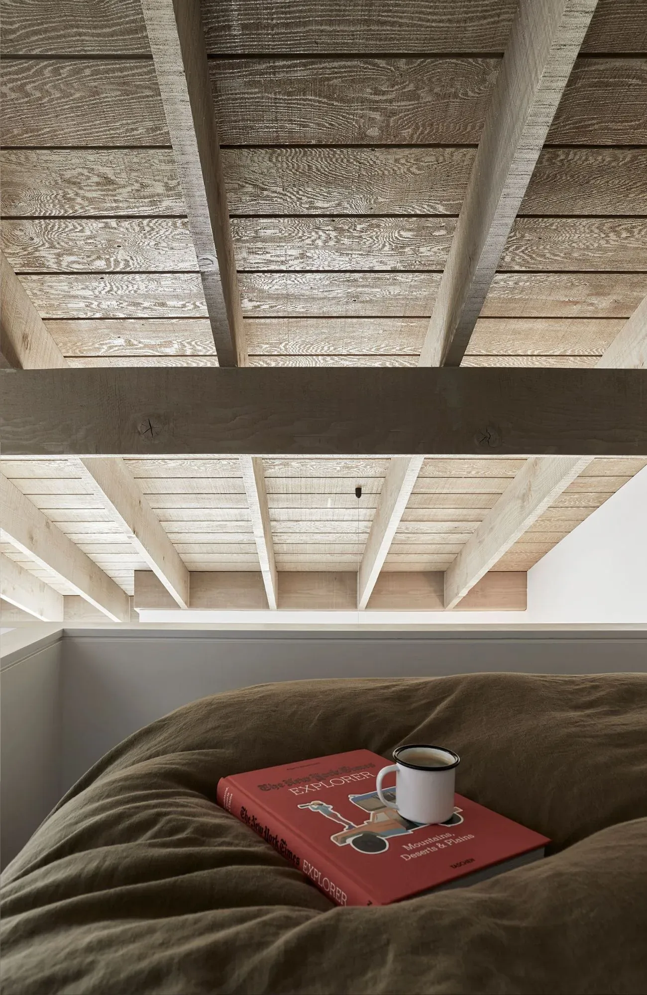 Cedar Cabin by Nicholas Gurney & Monique Easton. Coffee and book displayed in a cozy sleeping loft.