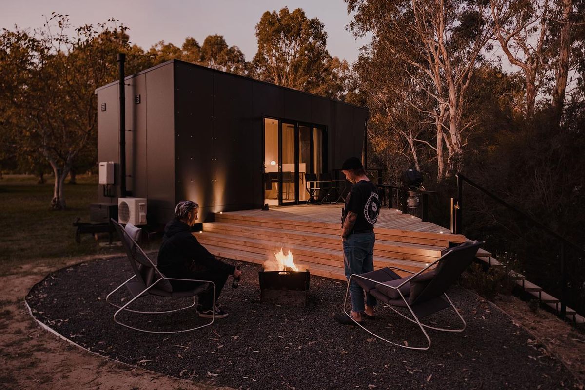 Cortes Cabin by Cortes Stays. Guests surrounding outdoor firepit.
