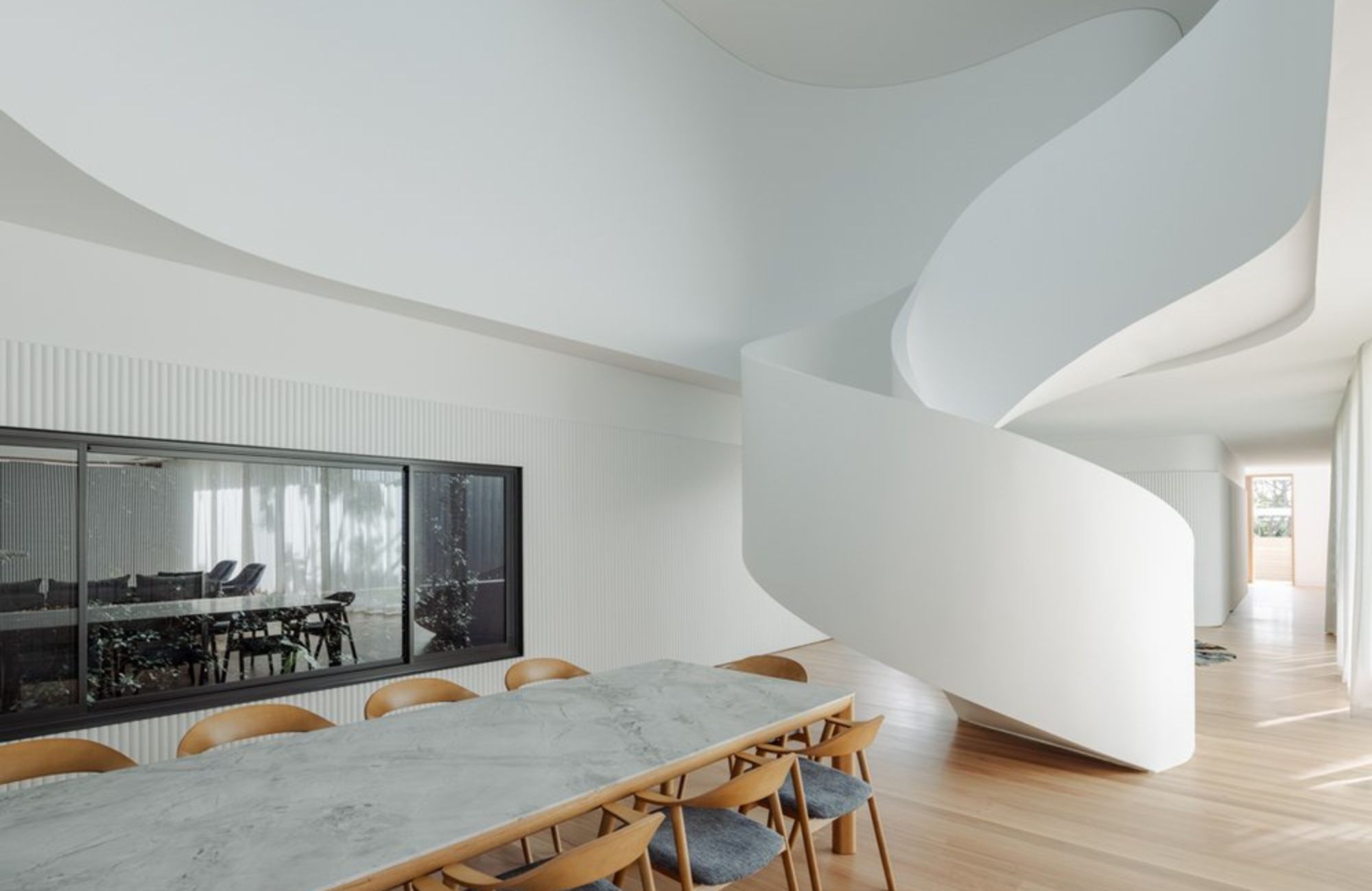 Boomerang House by Joe Adsett Architects. Dining view featuring spiral staircase