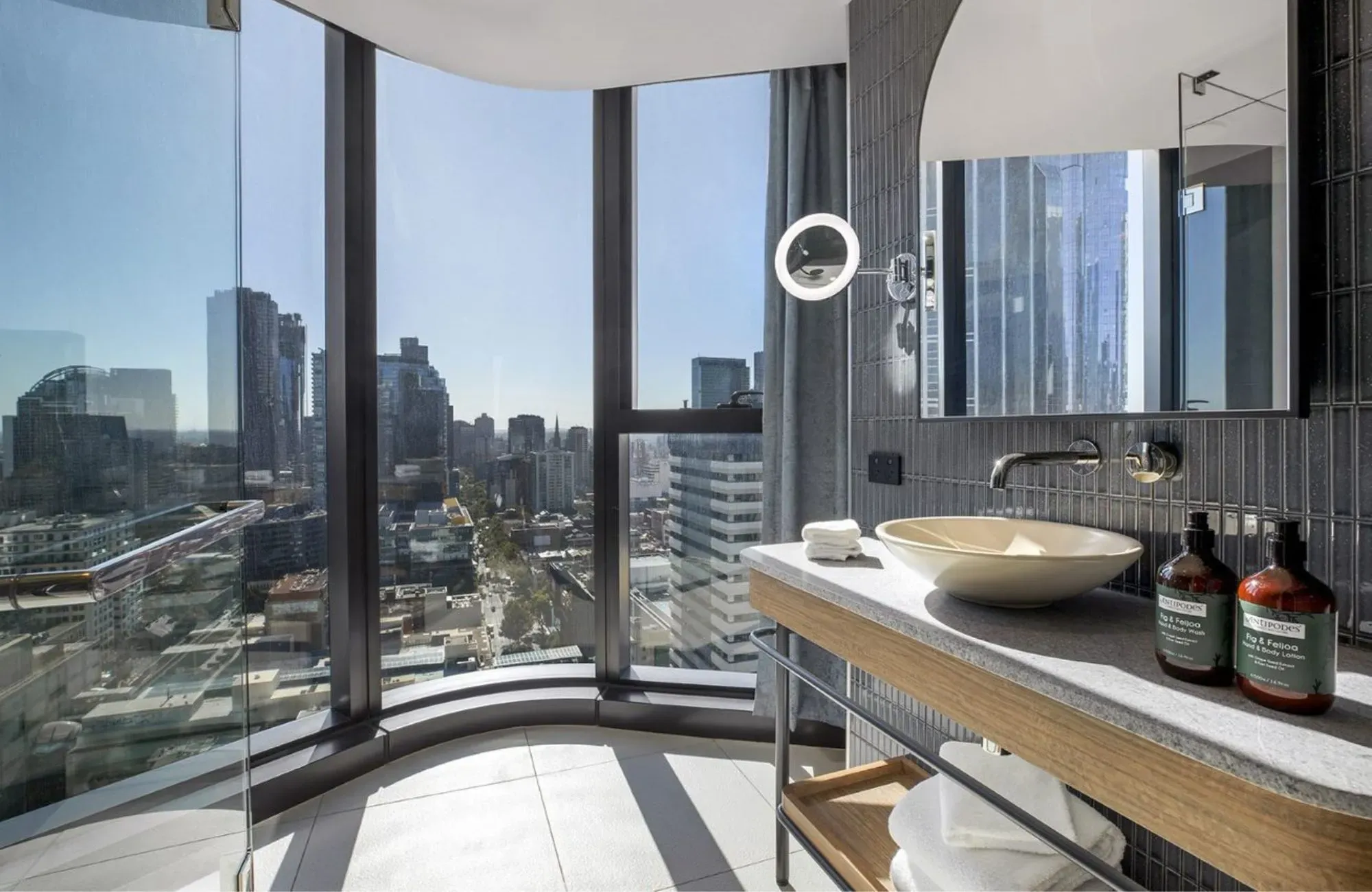 Voco Melbourne Central by IHG Hotels & Resorts. Guest bathroom, view out to city