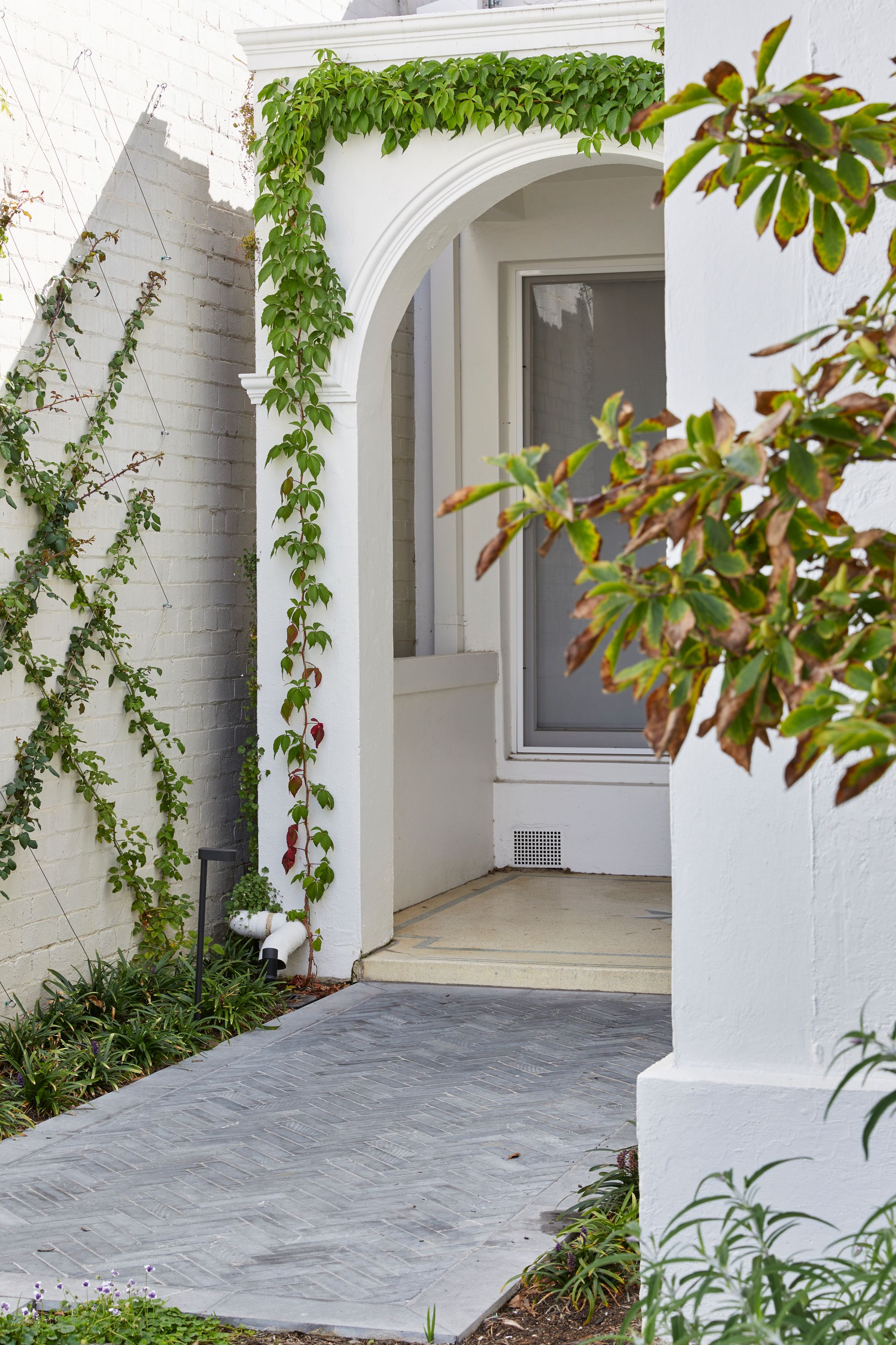 Carlton North Residence by Project 12 Architecture. Detailed view of facade entrance, featuring characteristics of traditional Victorian style cottage 