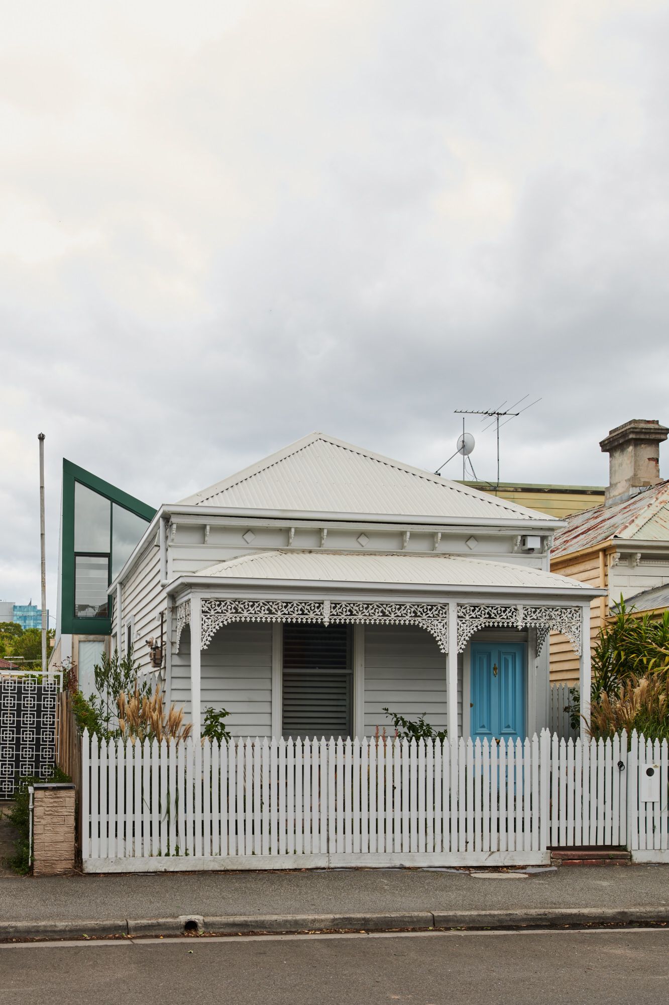 Hot Top Peak by FIGR Architecture. Street front showing existing cottage with a glimpse of the extension out back