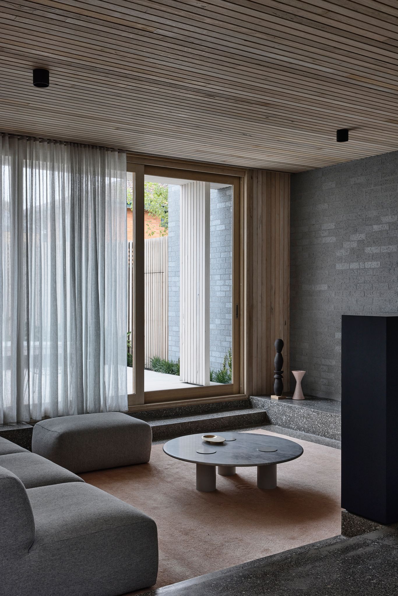 Silvertop House by Tom Robertson Architects. Sunkin living room with timber sliding doors connecting to couryard