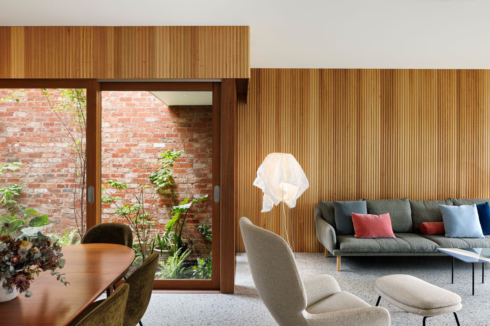 Tiara House by FMD Architects. Living room and dining room. View to external courtyard