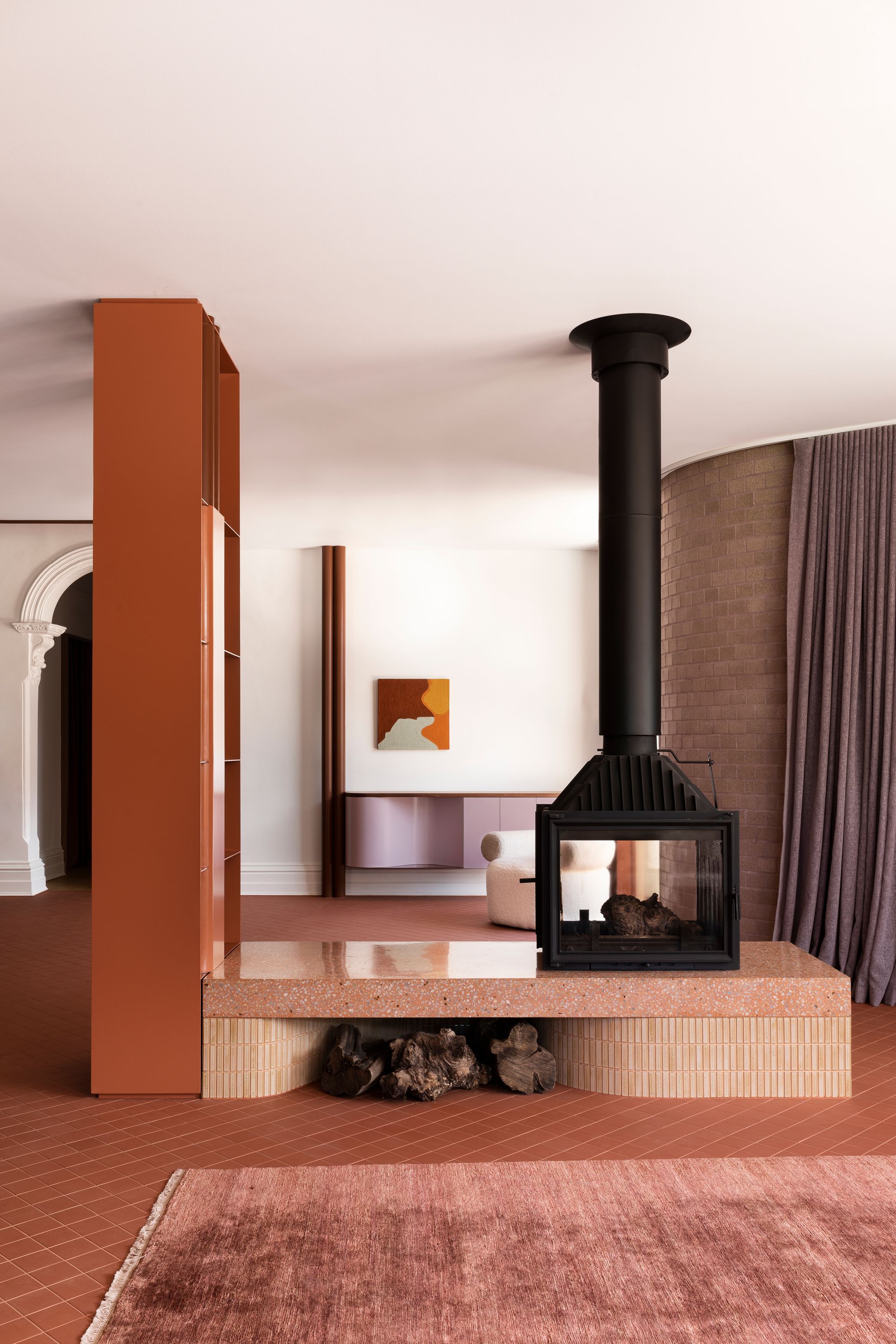 Hermon by WOWOWA. Fireplace diving the living spaces.