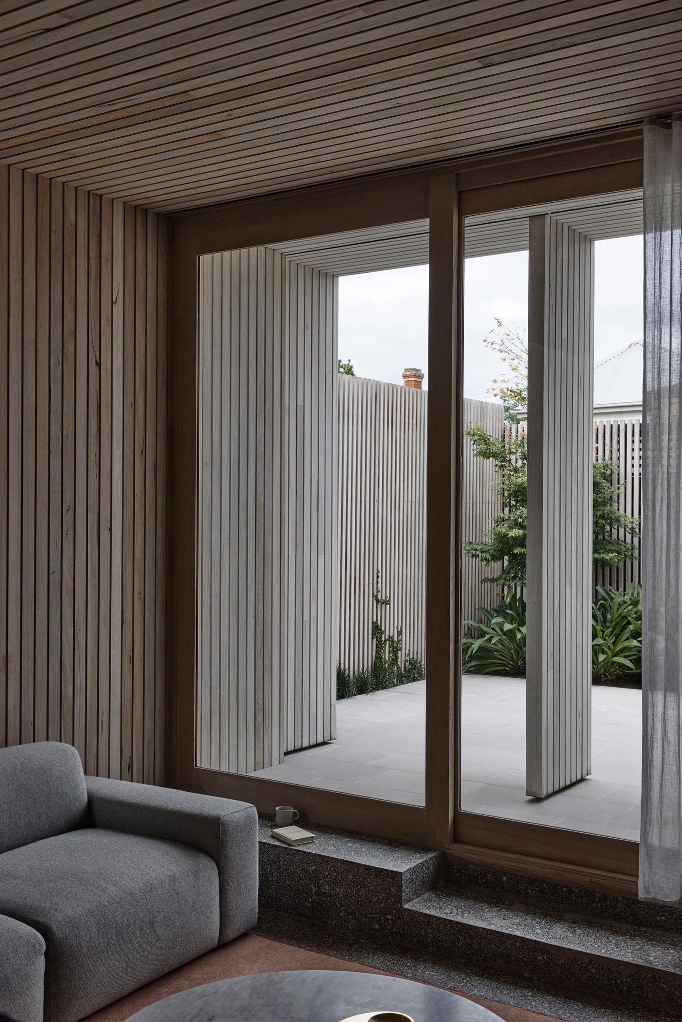 Silvertop House by Tom Robertson Architects. Detailed view of sunken living room with step leading out to courtyuard