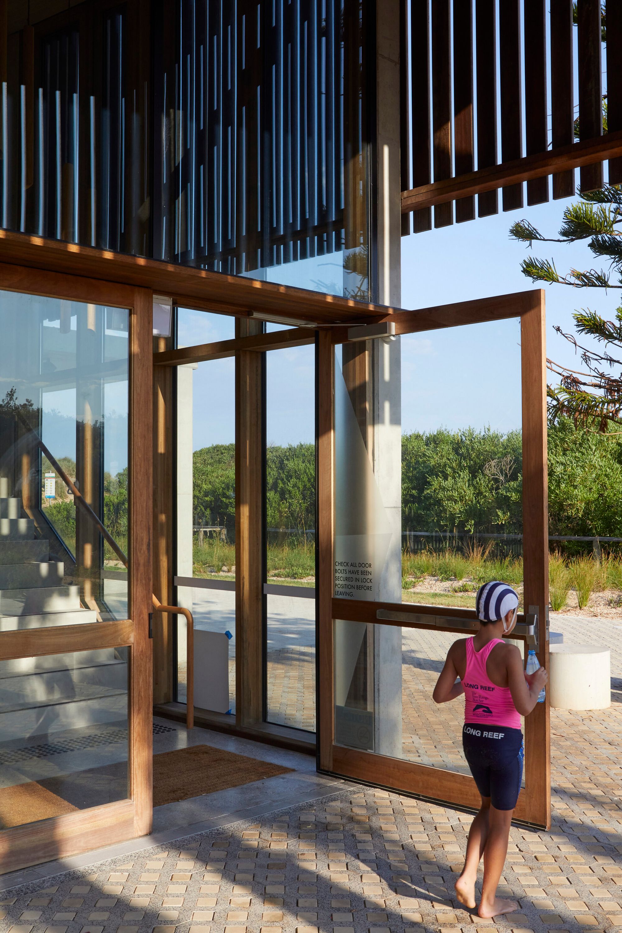 Long Reef SLSC by Adriano Pupilli Architects showing open timber and glass door