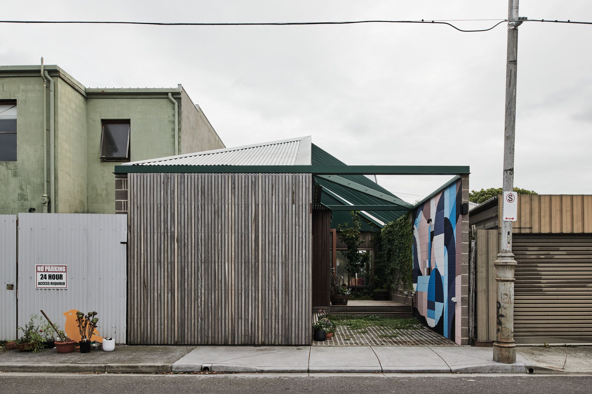 Hot Top Peak by FIGR Architecture. Back street frontage, sliding gate open to view into courtyard