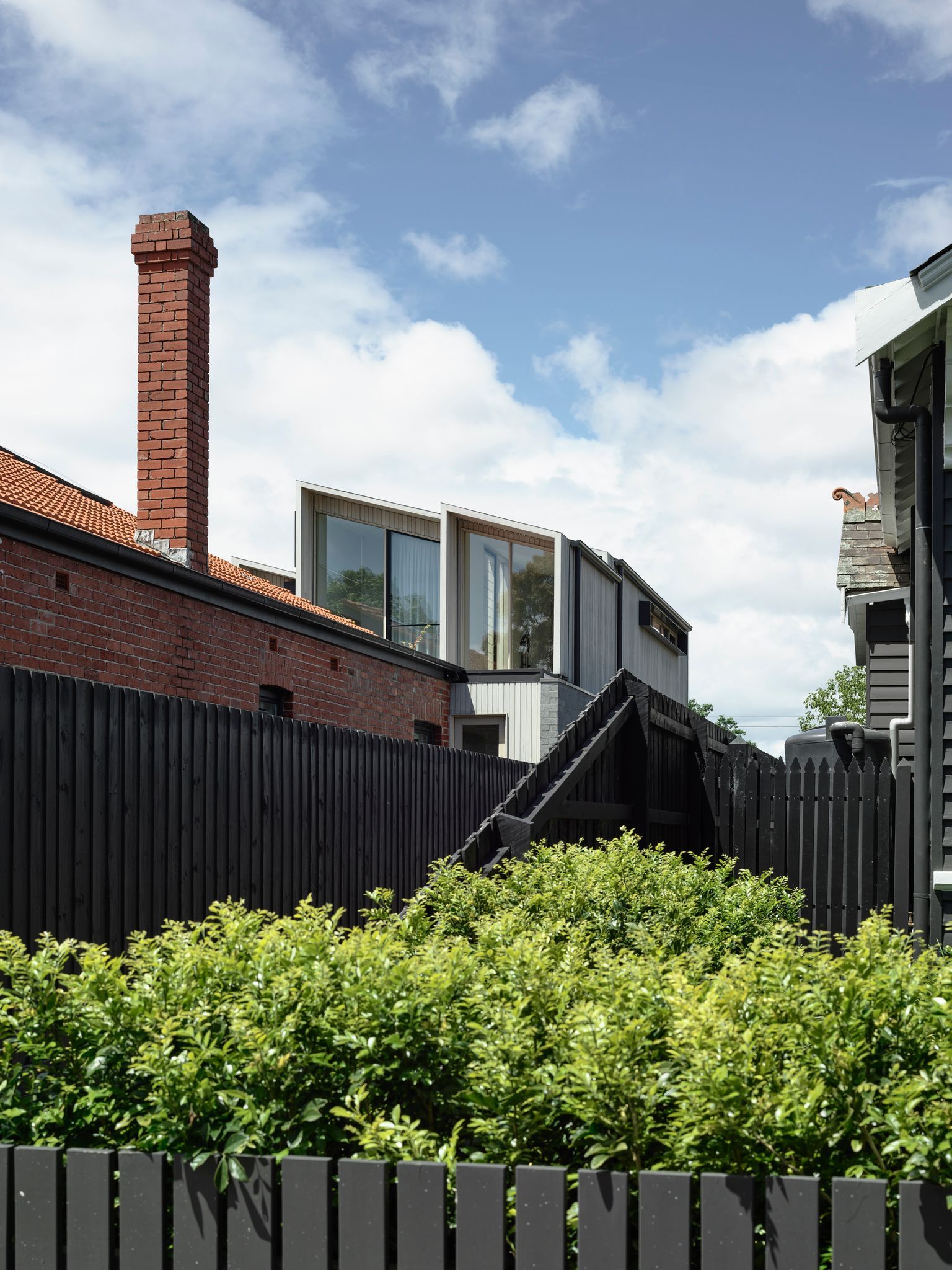 Silvertop House by Tom Robertson Architects. View from street showcasing original home and rear extension