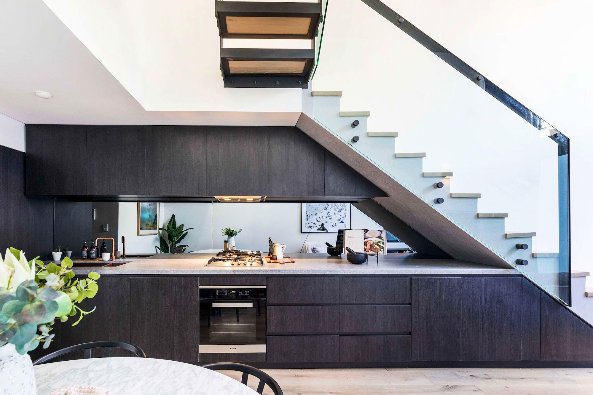 Darlinghurst Residence by JKMarchitects showing kitchen joinery located under feature stair