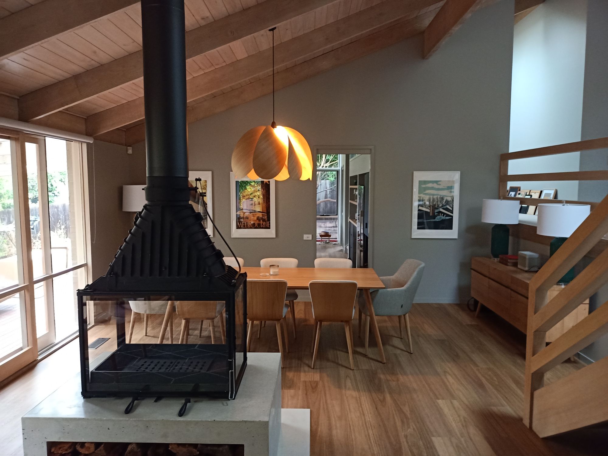 Duncan Meerding's Propeller Blossom Pendant hanging over a dining table with a fireplace in the foreground