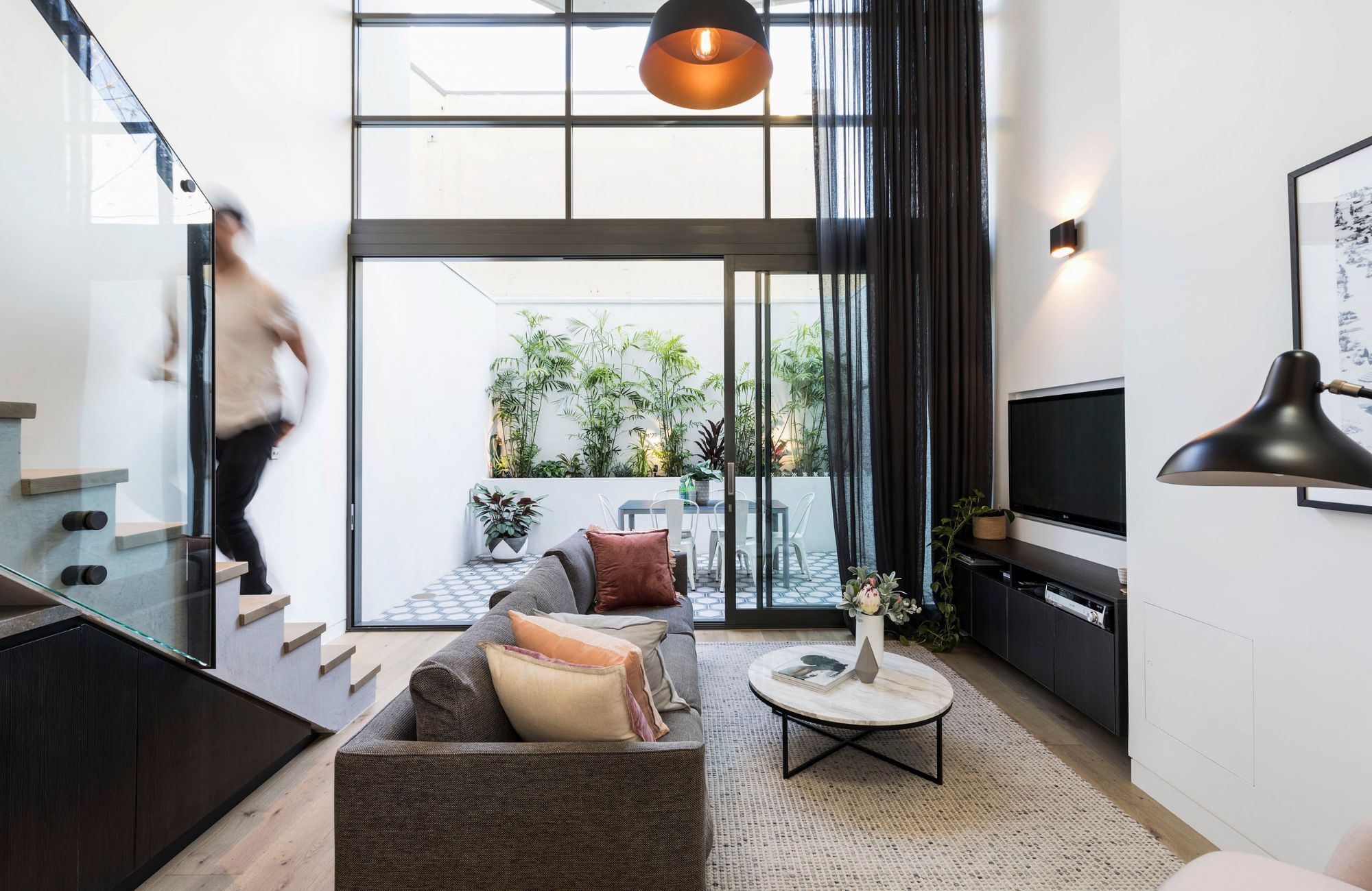 Darlinghurst Residence by JKMarchitect showing interior of living room with large steel doors
