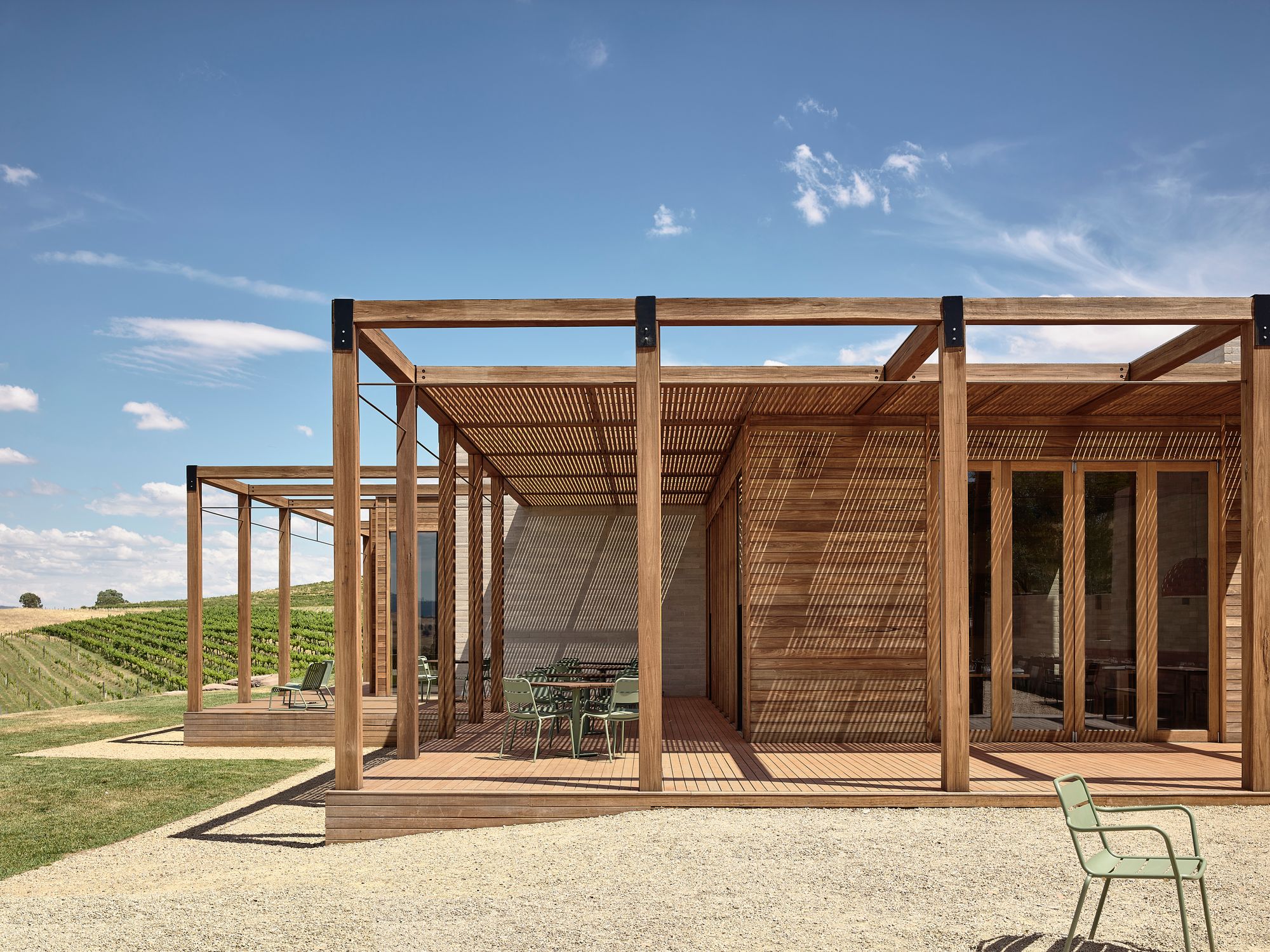 Delatite Cellar Door by Lucy Clemenger Architects. Outside Delatite, structure looking of to vines. 