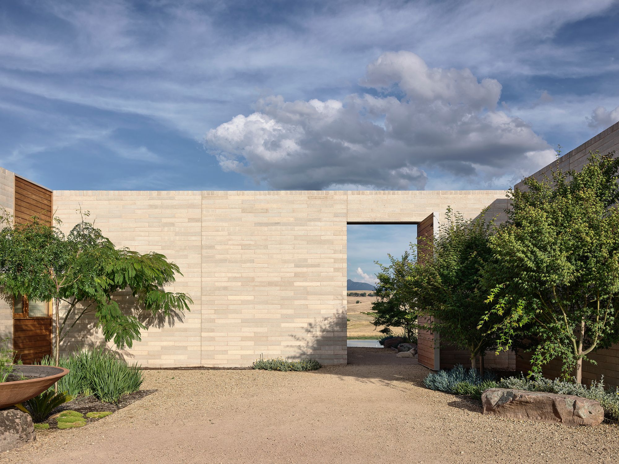 Delatite Cellar Door by Lucy Clemenger Architects. Inside courtyard, Timbercrete blade wall opening up to surrounding property. 