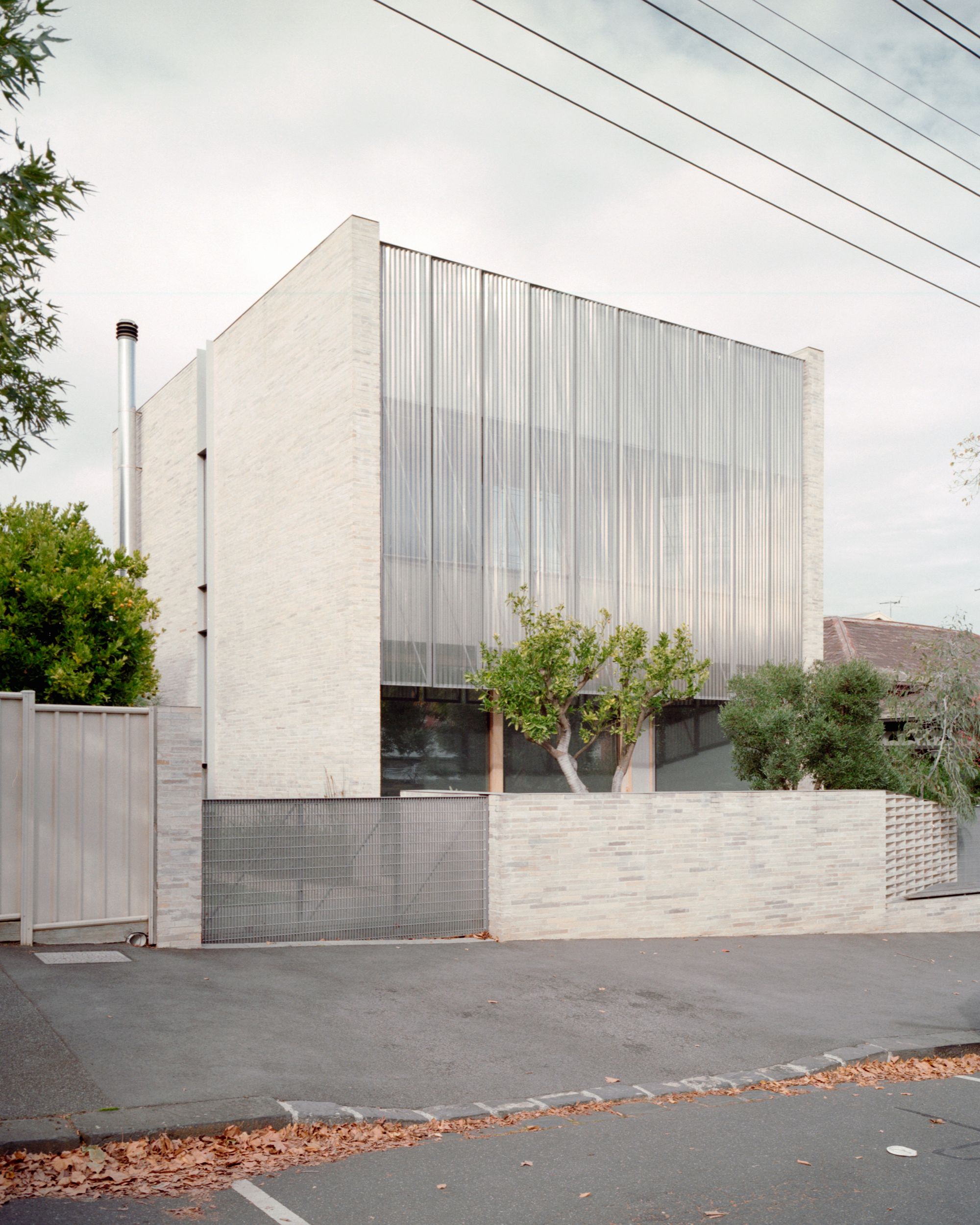 Divided House by JCB Architects. Sreet view of Front facade of residential project, featuring a cloudy tone. 