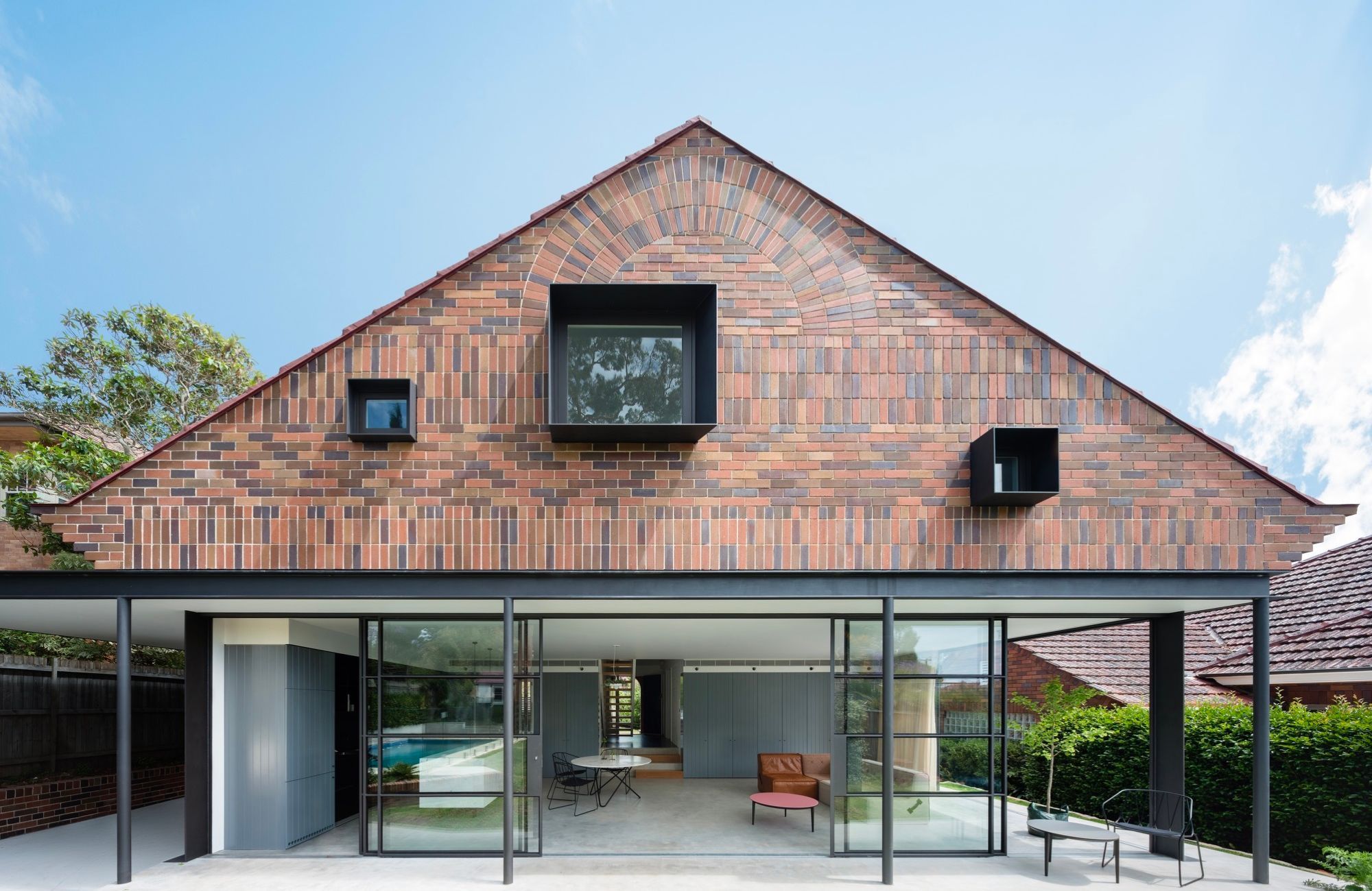 House Au Yeng by Tribe Studio Architects showing brick facade and steel doors