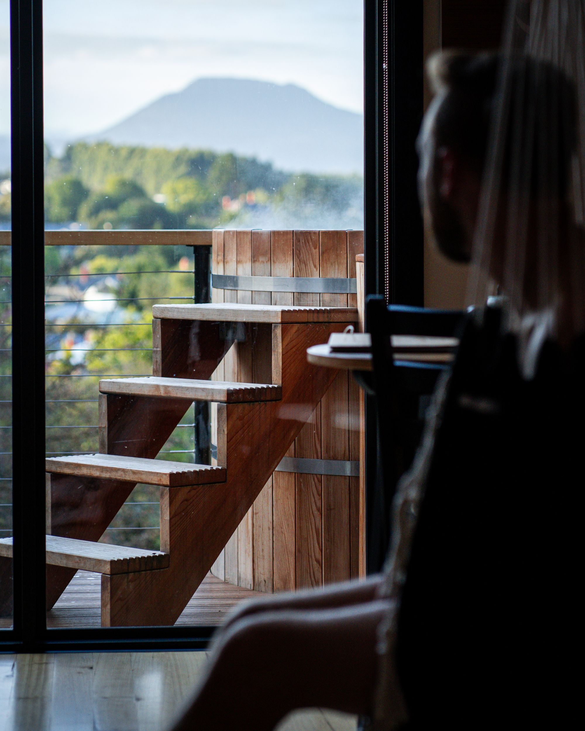 The Eco Cabin Tasmania by Wild Life Environmental. Detailed view of guest looking out to cedar hot tub and view