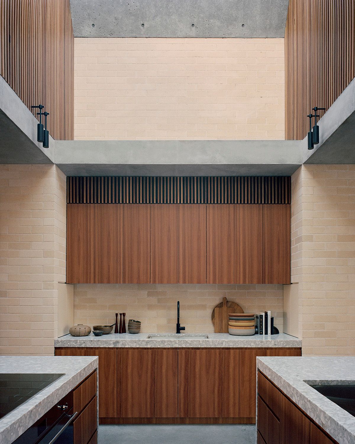 Bronte House by Tribe Studio Architects showing timber and brick kitchen with a void space over