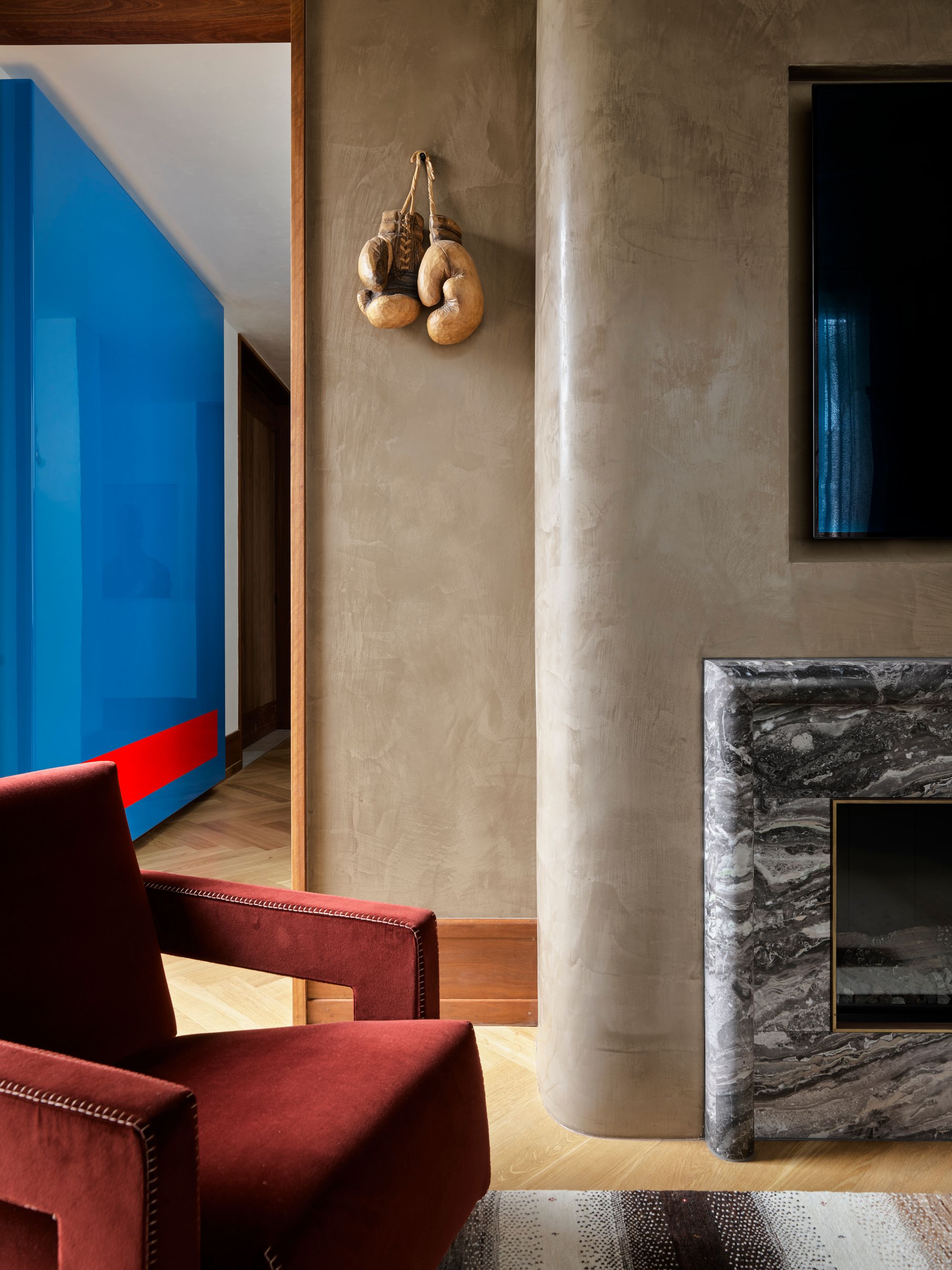 amarama by Flakk Studio featuring Waterstone.  Living room area detailed view of chair and fireplace. 