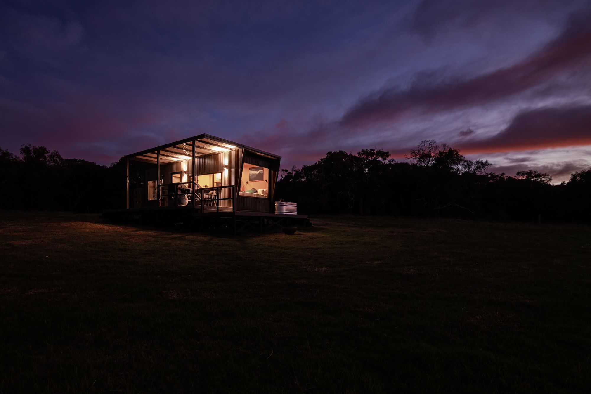 Heyscape Tiny Cabins. View of cabin at sunset. 