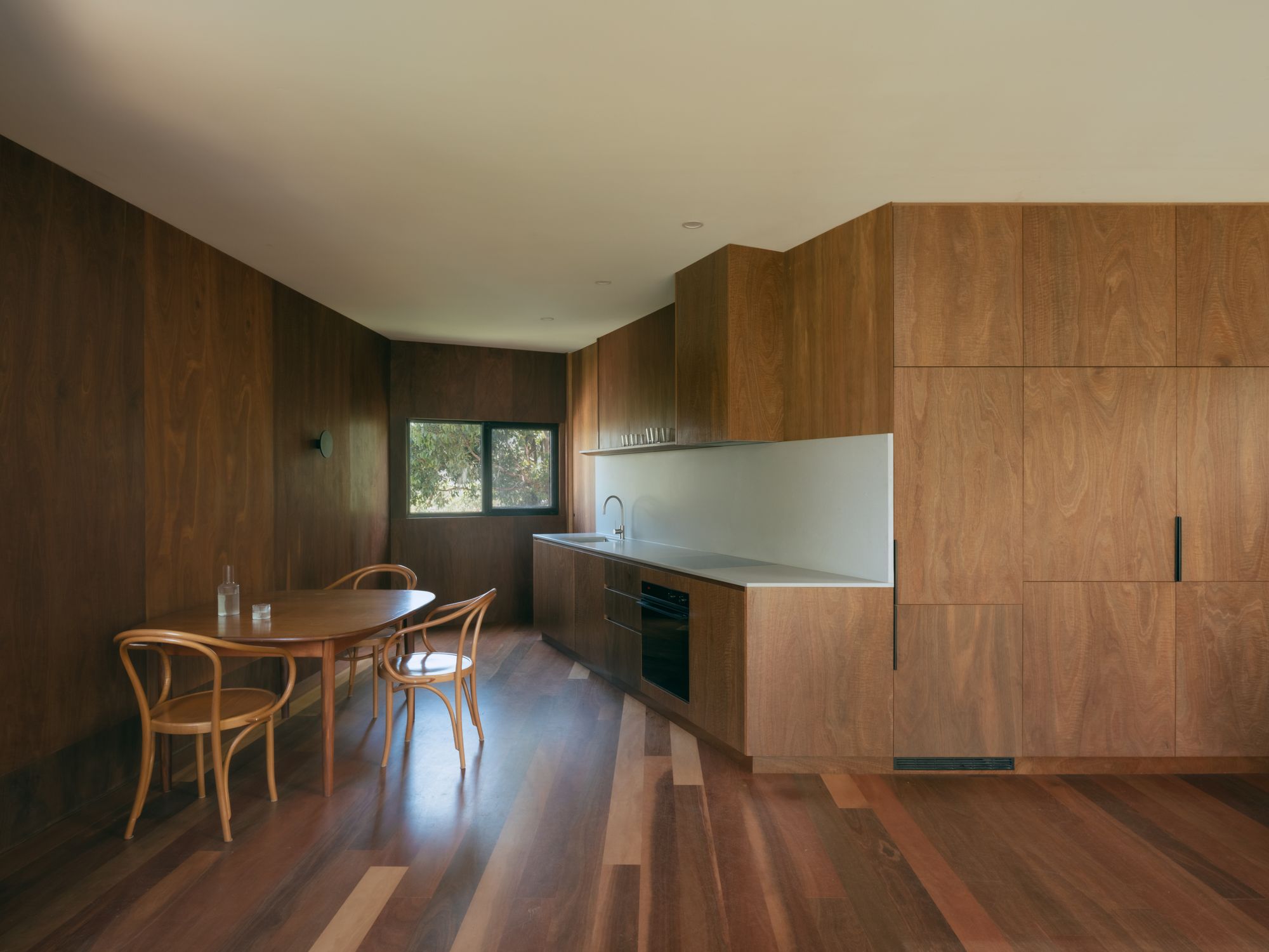 Kennett River House by MGAO showing timber joinery and floor of kitchen and dining space