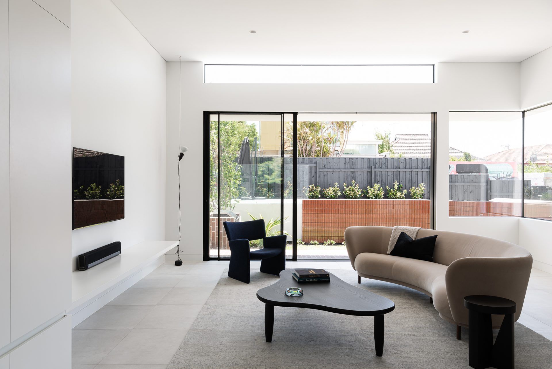 Hyde Park House by Robeson Architects. Close up shot of modern living space with white walls and floors. Modern minimalistic couches and organic coffee table. 