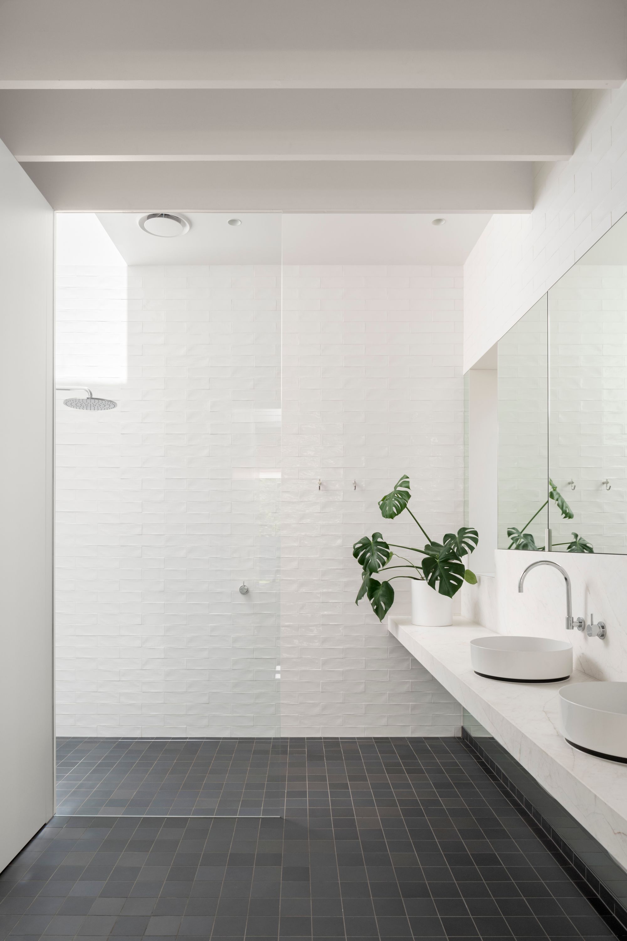 Elwood House by AM Architecture showing interior view of the bathroom with white and grey tiles
