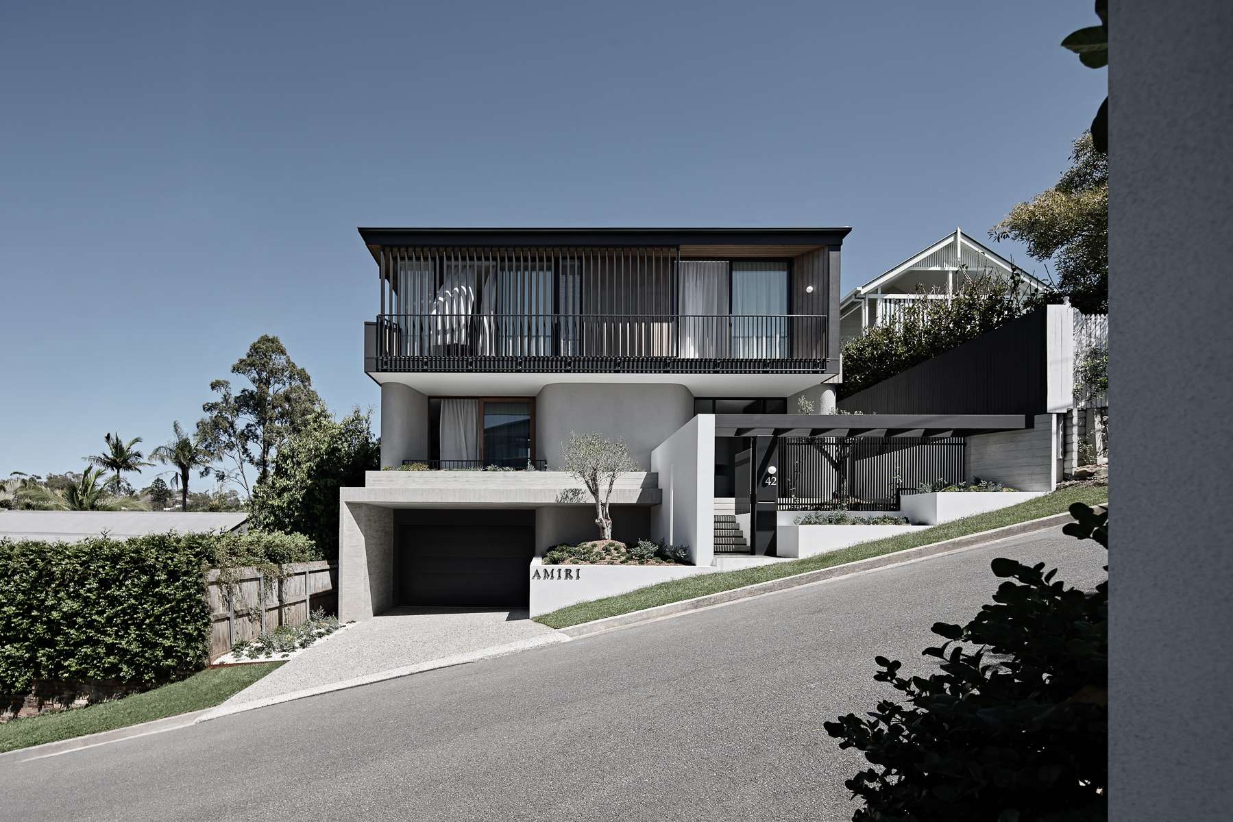 Amiri Courtyard House by Kelder Architects showing street view of sloping site