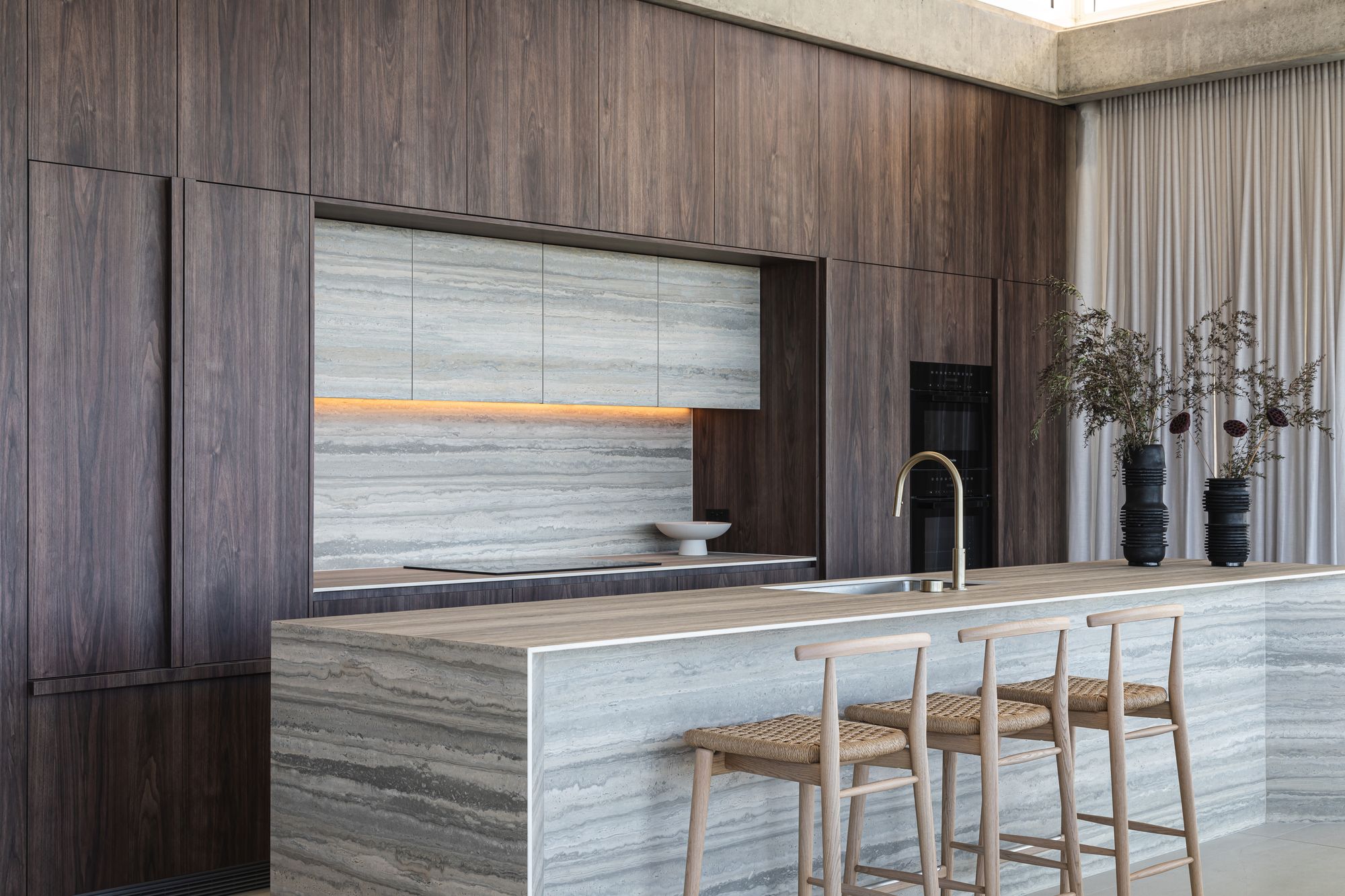 Cliffhanger by Joe Adsett Architects showing the interior view of the kitchen with timber veneer and marble
