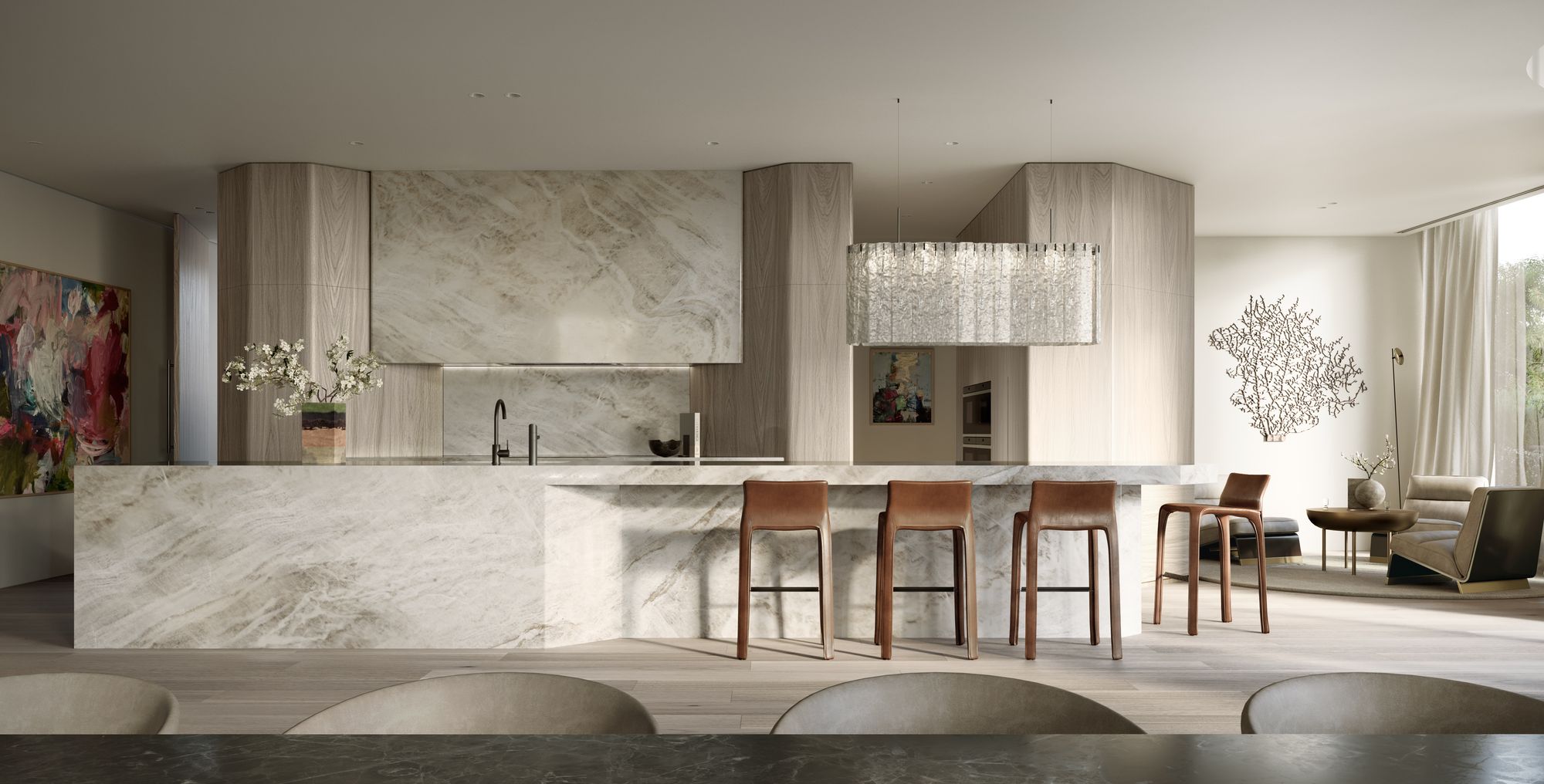 Como Toorak by Prime Edition x Jolson.displays a luxurious, modern kitchen interior with an open plan, blending effortlessly into a living area. The kitchen features a marble island and backsplash that provide a sleek and sophisticated look. The warm wood tones of the cabinetry contrast elegantly with the cool marble, creating a balanced aesthetic.