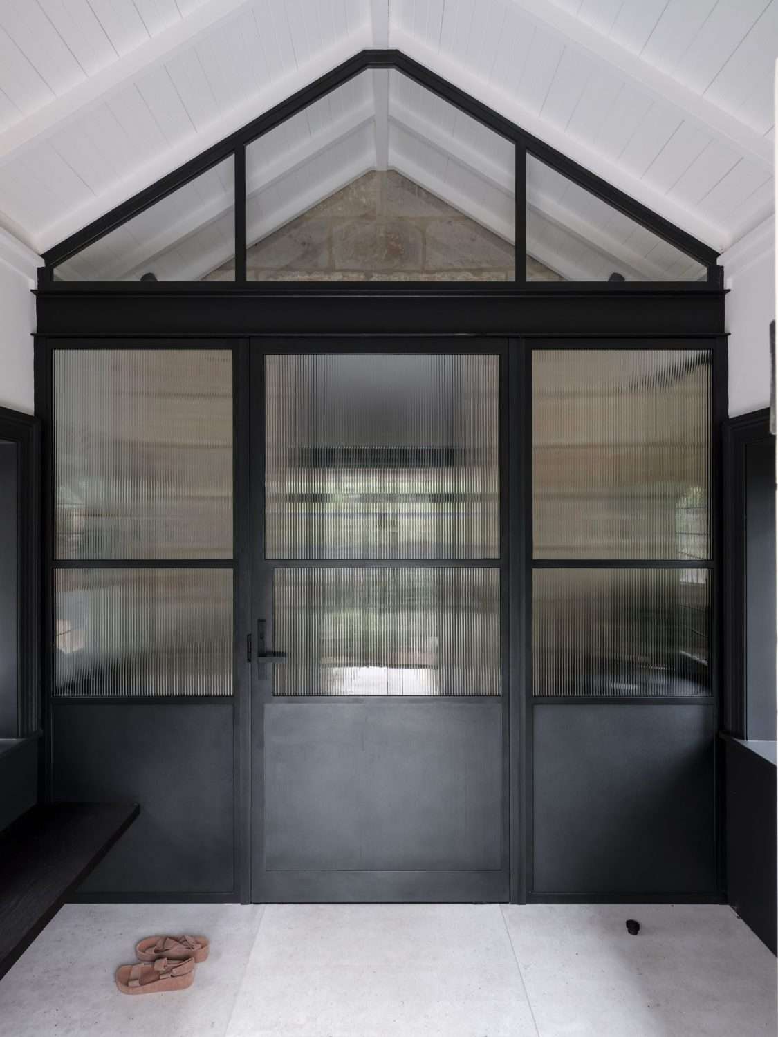 Maranatha House by BIJL Architecture showing house entry with large black steel doors with fluted glass