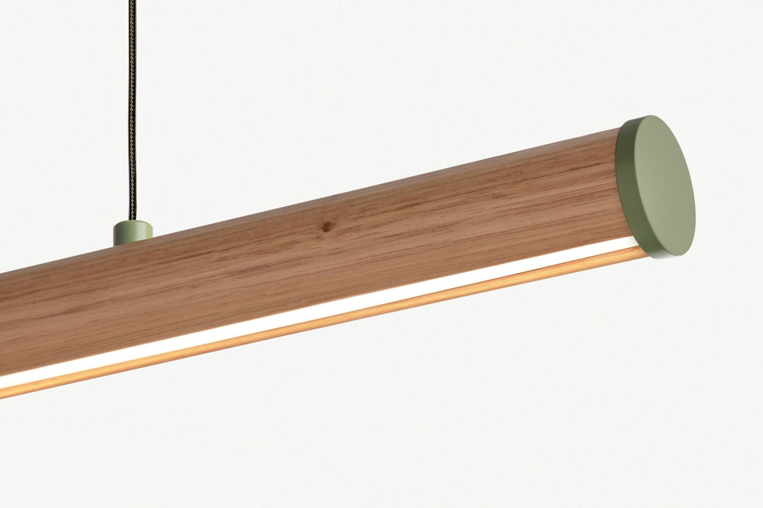 The Roller is a classic dowel pendant with a subtle curved edge to catch the LED light and create a unique gradient effect. A versatile cylindrical pendant crafted from bespoke timbers. Finished in Victorian ash with a custom green cap colour. 