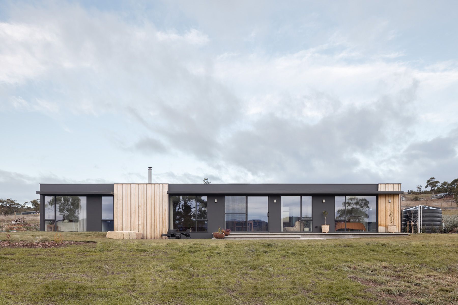 We Ponder House by Saxon Hall Architecture with Align Architecture showing the read of the house sitting in the landscape