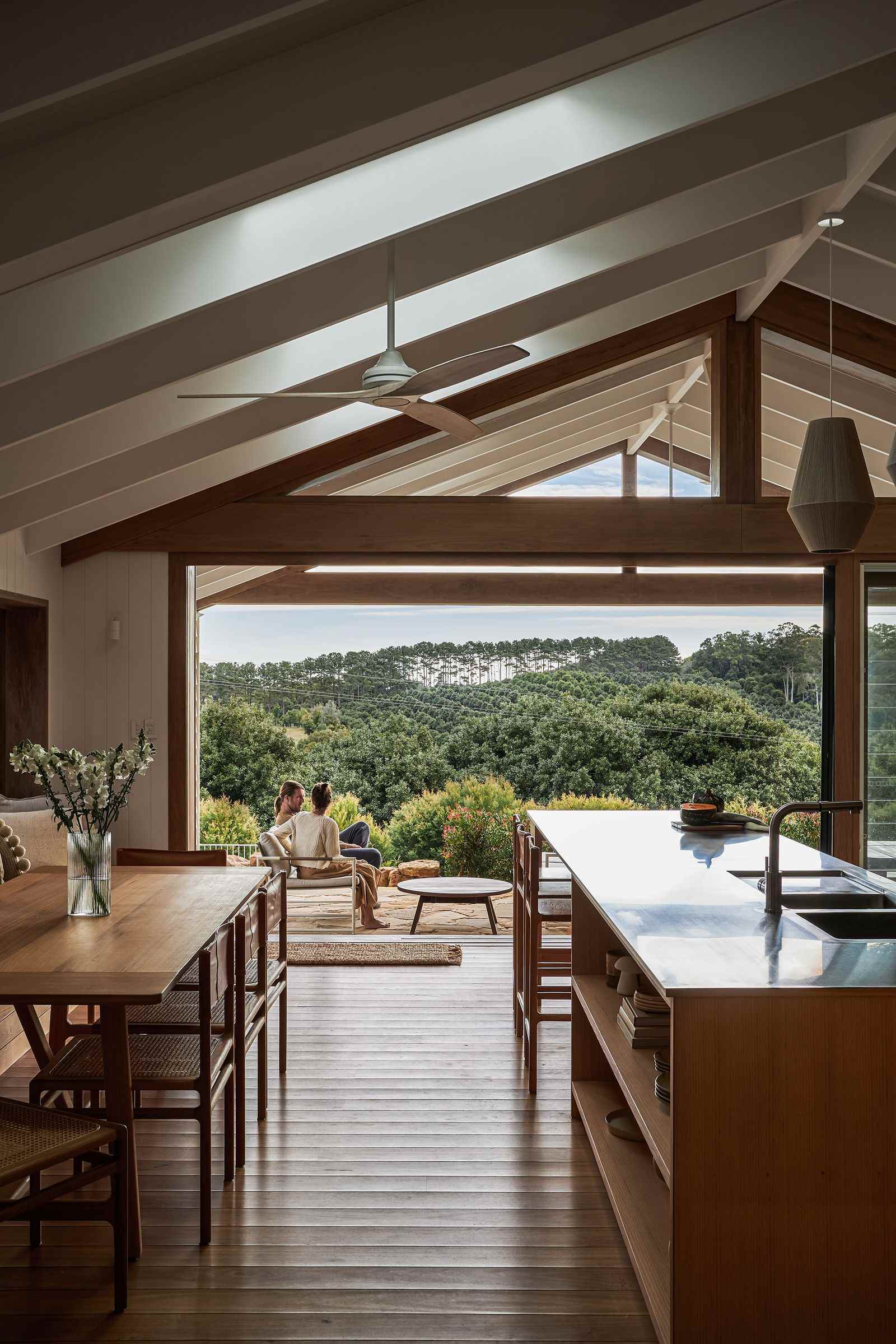 The Caretaker's by Aphora Architecture showing an interior view of the kitchen / dining space looking out to the hinterland