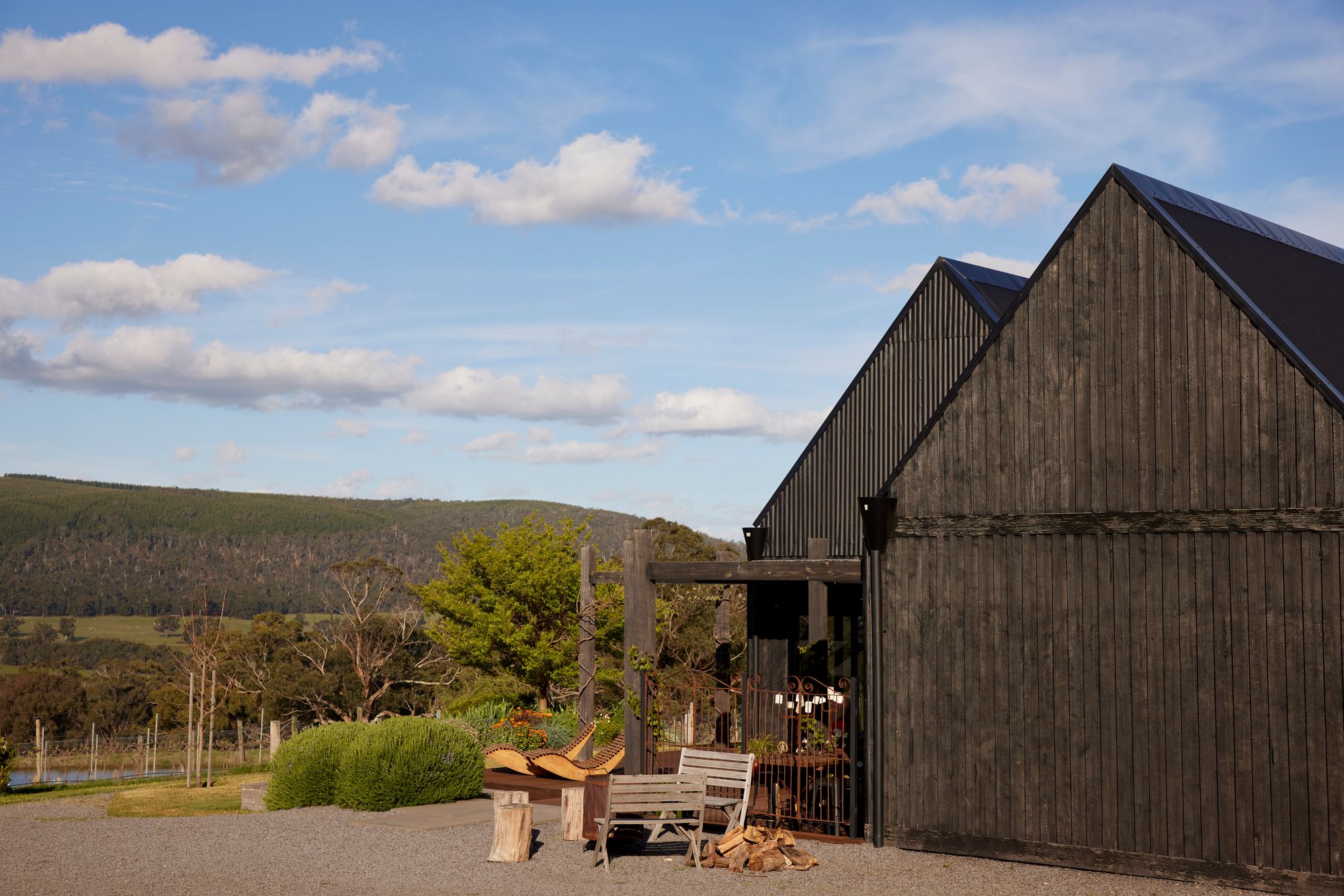 An exterior shot of The Glut Farm showing the dark timber cladding that covers the two pavilions