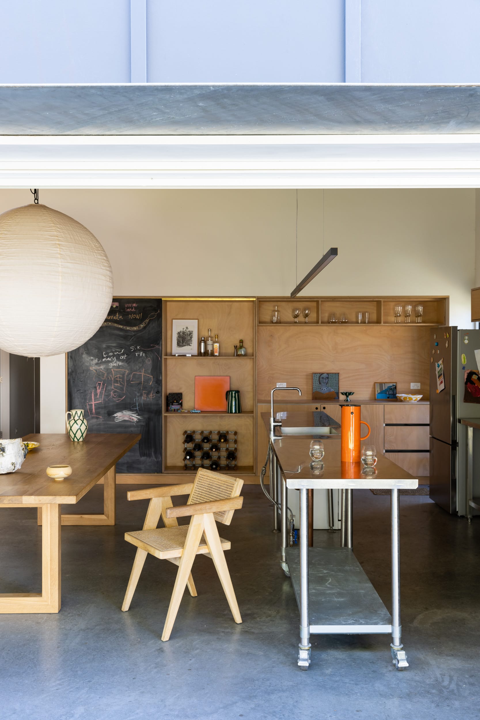 Drip-Dry House by Marker Architecture & Design. An interior shot of the industrial style kitchen and dining table with a large pendant light over