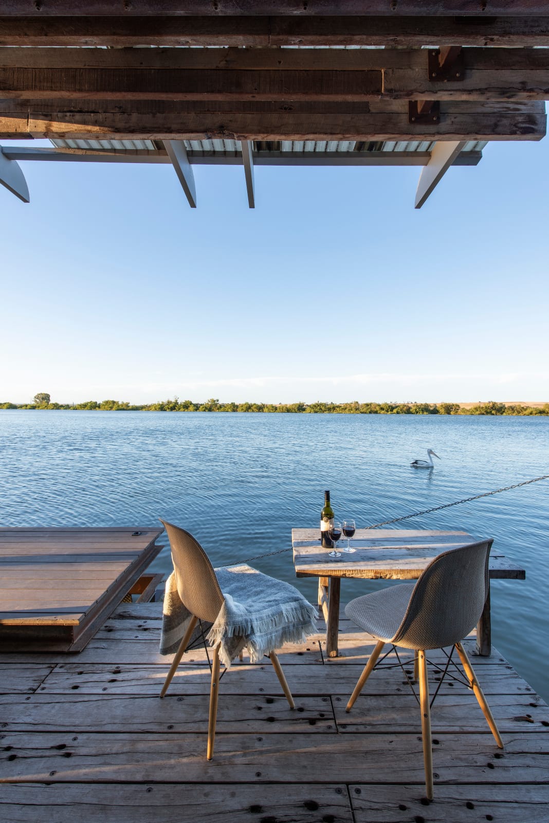 Bill's Boathouse. An exterior deck shot showing the outdoor furniture that guests can enjoy with a bottle of wine on the table