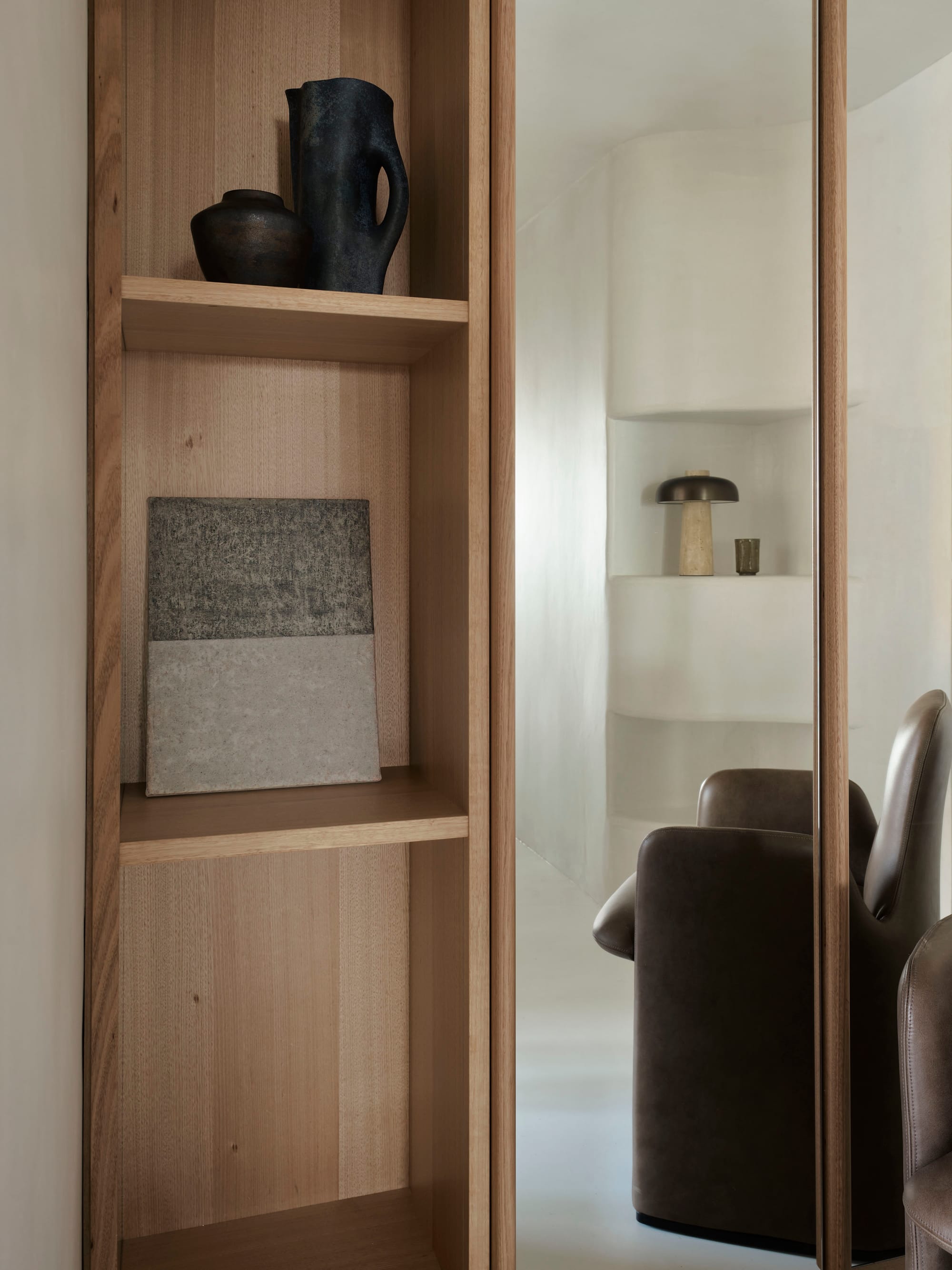 A detail shot of the Tasmanian timber veneer shelves and designer objects scattered throughout the apartment