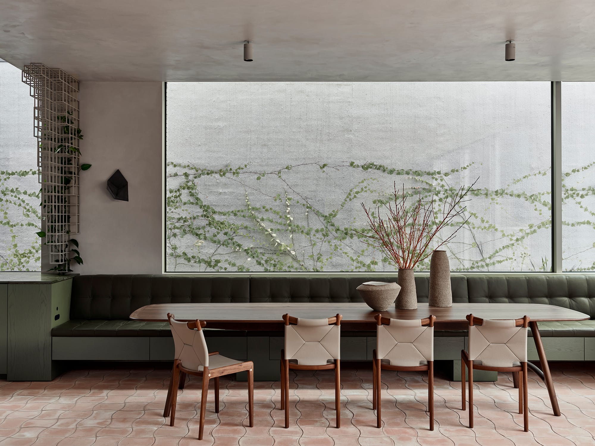 Terra Firma by RobsonRak. Photography by Mark Roper showing the banquet seating in the dining room and view out to a brick wall with a green creeper