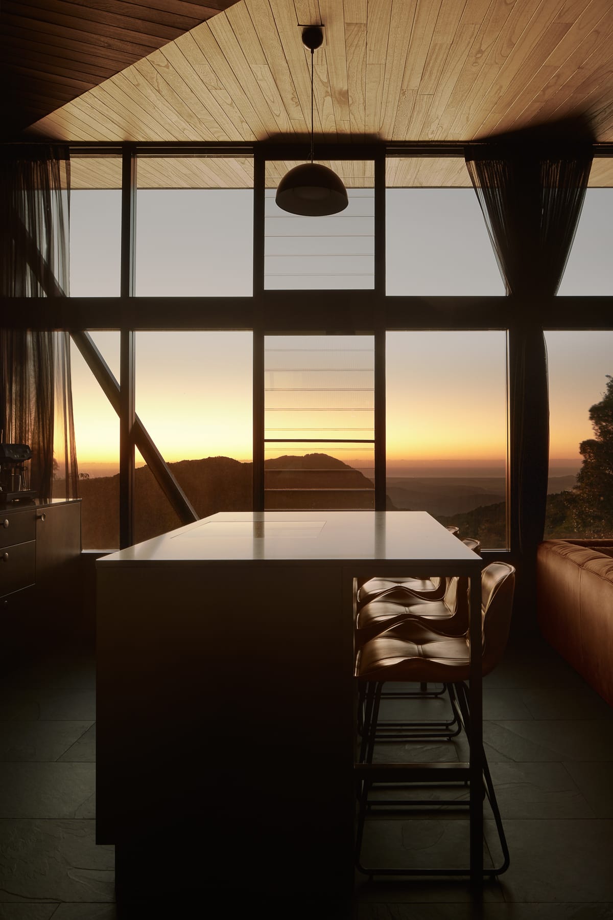 An interior shot of the kitchen showing the view at sunset making the interior of the cabin orange