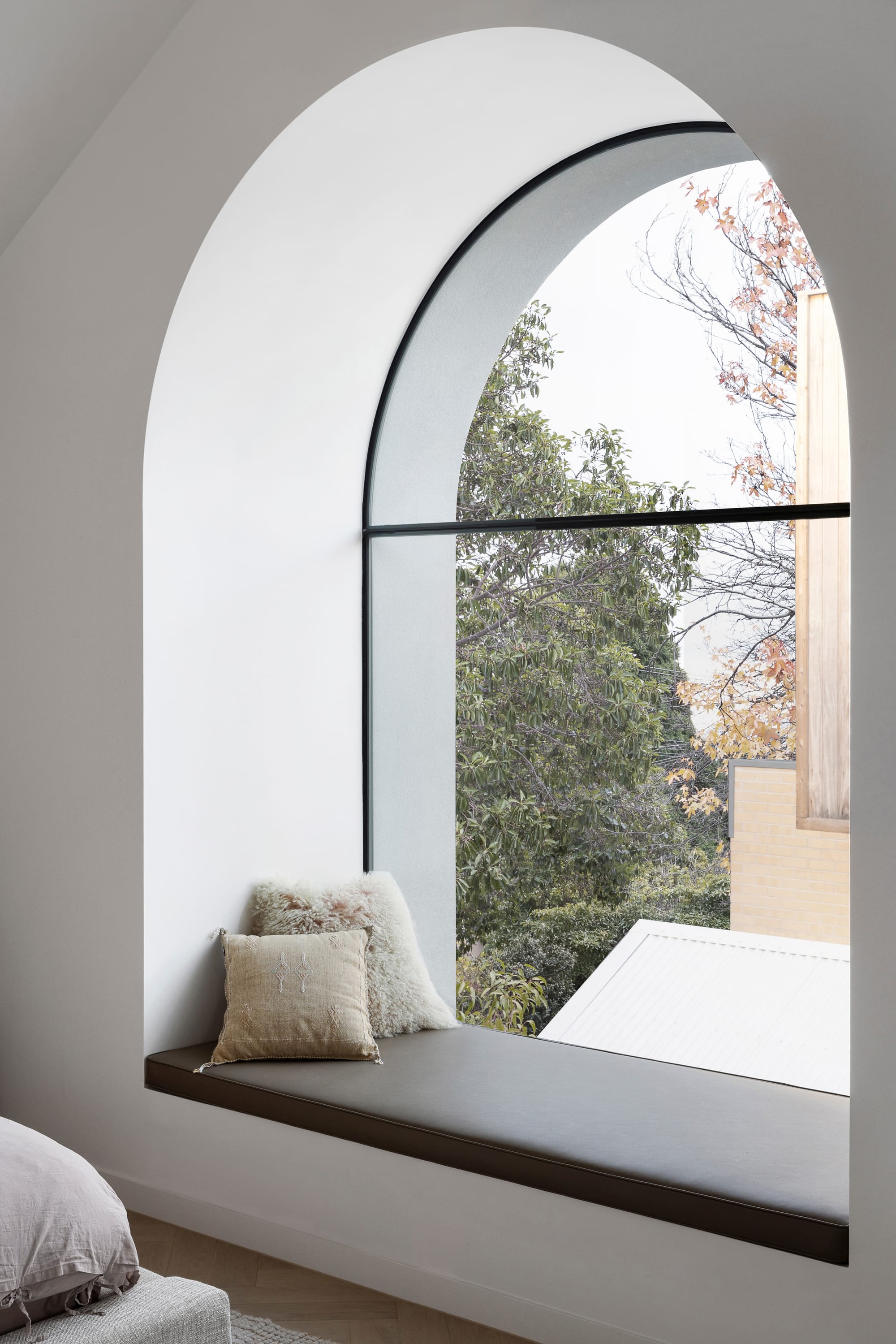 Goldsmith Residence by C.Kairouz Architects. Photography by Spacecraft. Arched bay window with grey cushion in bedroom. 