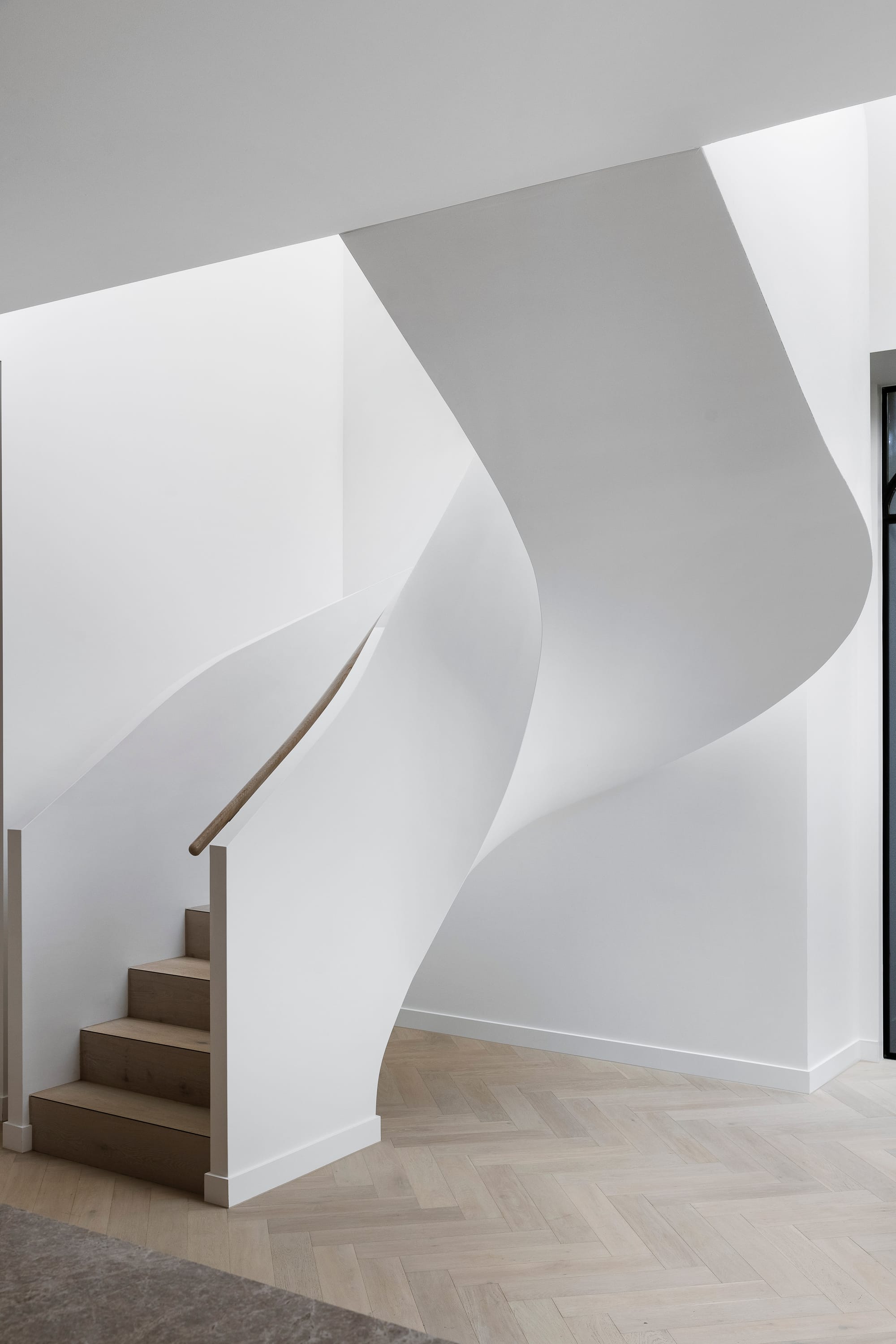 Goldsmith Residence by C.Kairouz Architects. Photography by Spacecraft. Curved white contemporary staircase with timber steps and balustrade. Pale timber herringbone floors. 