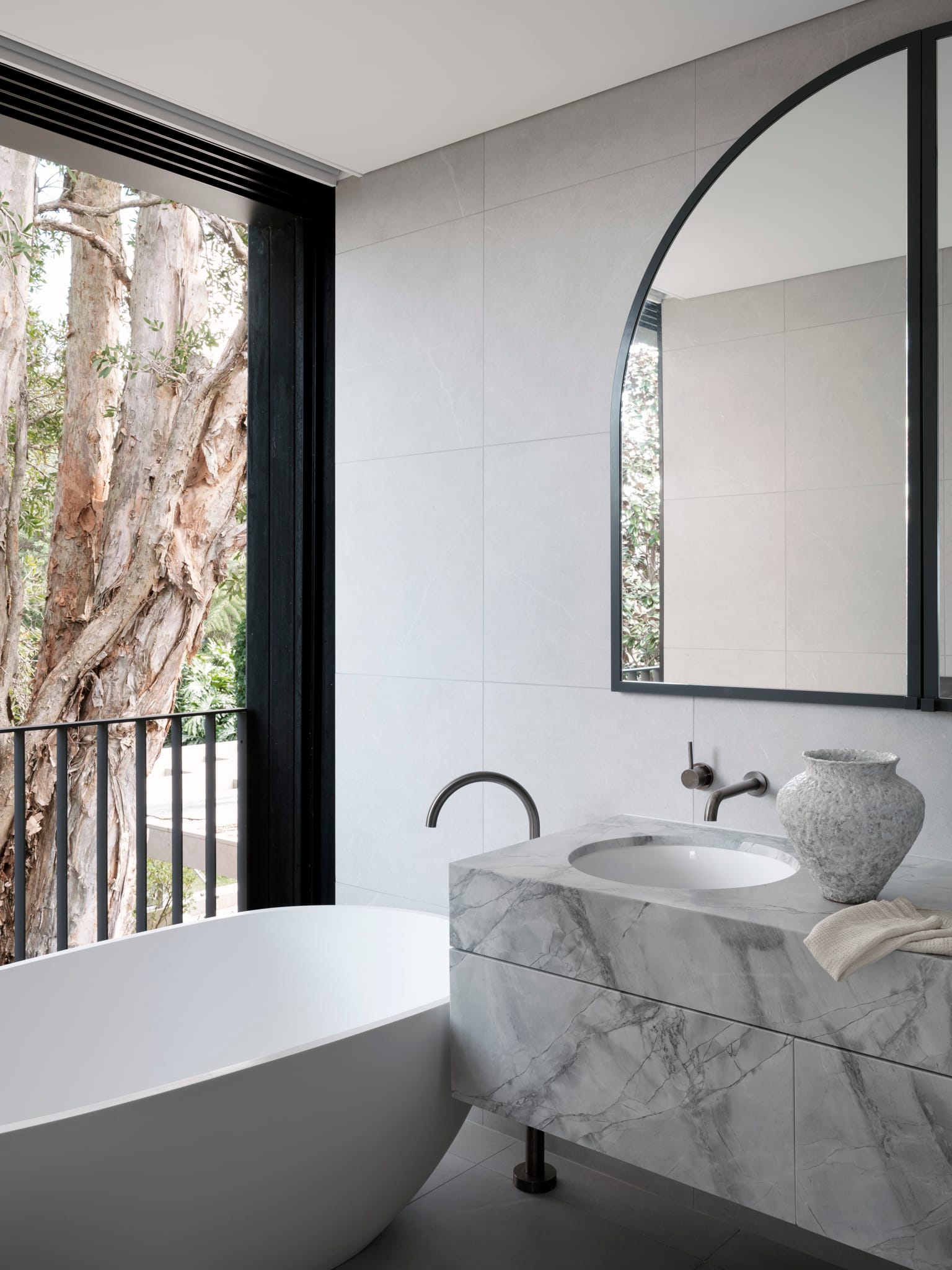 Bellevue House by Carla Middleton Architects. Photography by Tom Ferguson. Bathroom with marble vanity and freestanding bath. White wall tiles and dark grey floor tiles. 