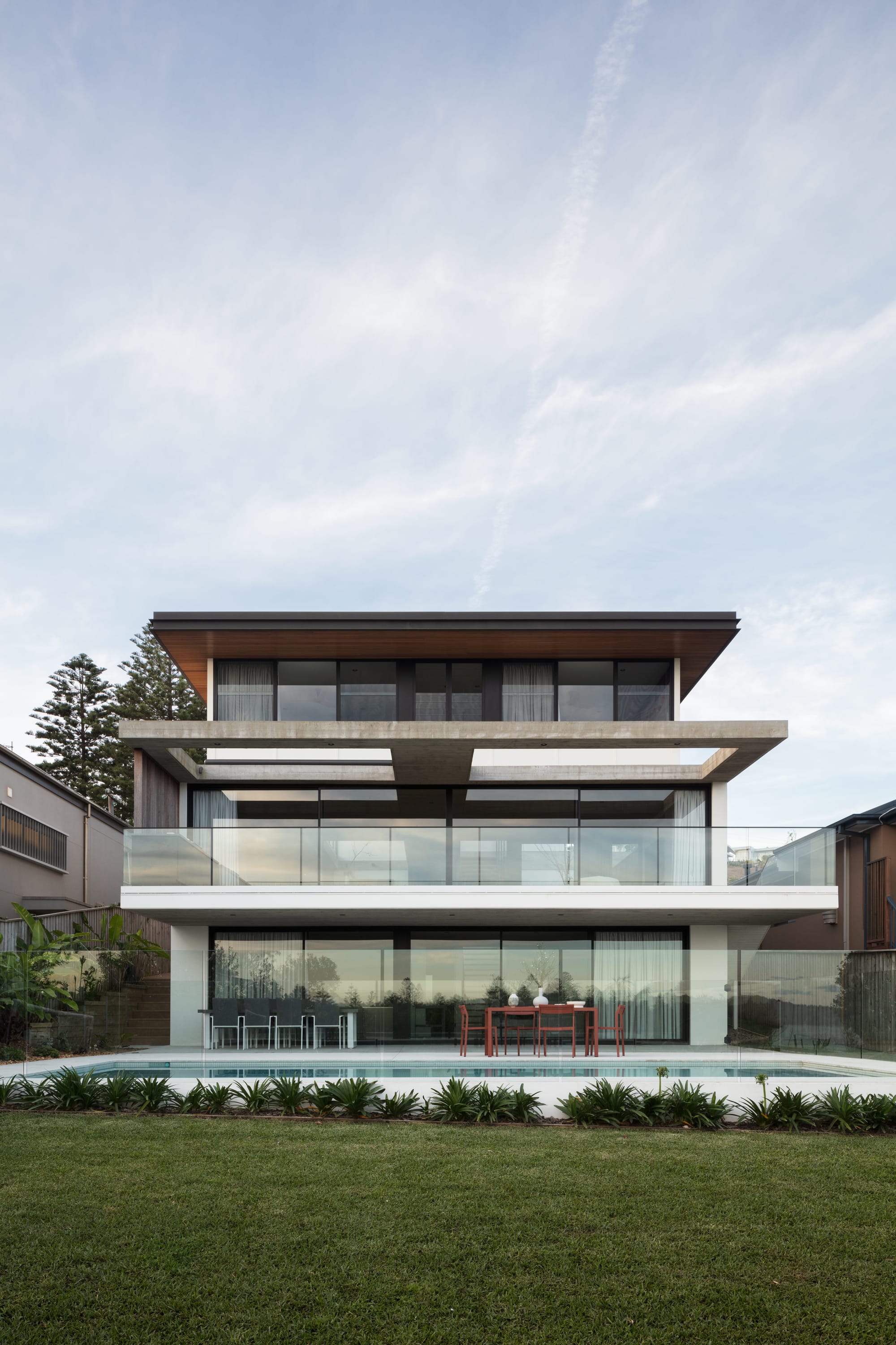 Grandview House by Ian Bennett Design Studio. Photography by Clinton Weaver. Rear facade of triple storey home with balcony and pool. 