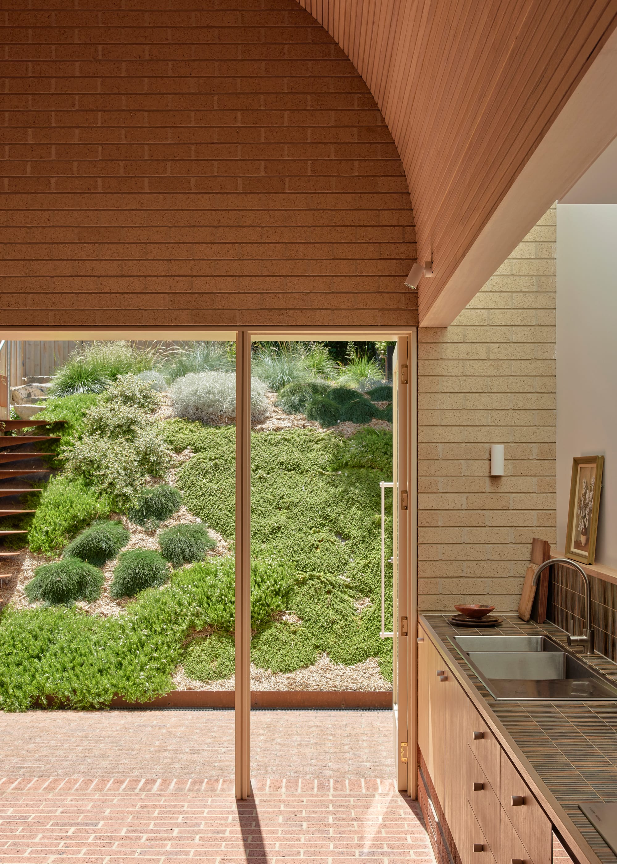 Harriet's House by SO:Architecture. Photography by Sean Fennessy. Tall arched ceiling clad with Tasmanian Oak. Brick floors inside and out. Sloping garden covered with low-lying plants.