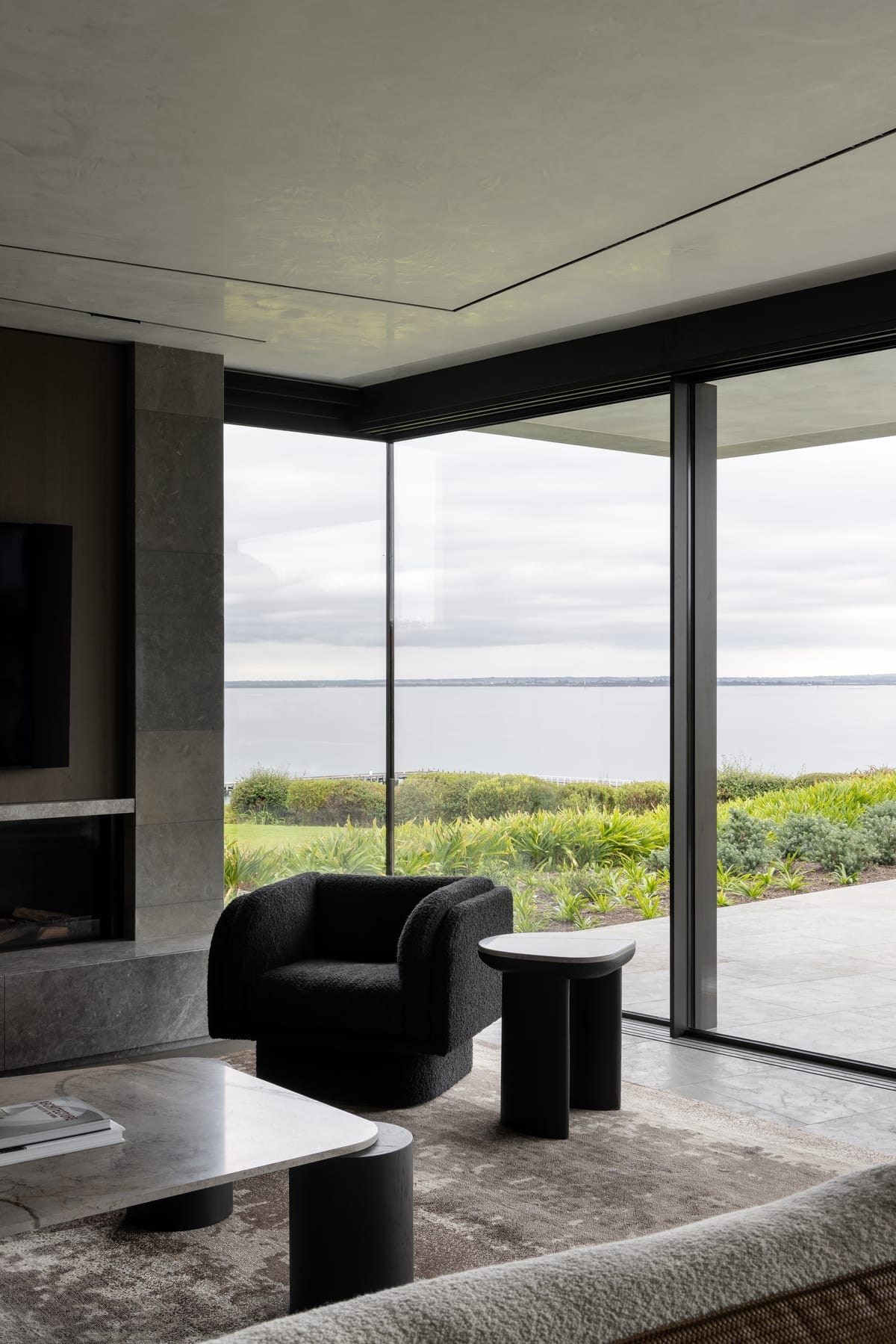 Cliff House by Finnis Architects. Photography by Timothy Kaye. Armchair in front of window, overlooking ocean. 