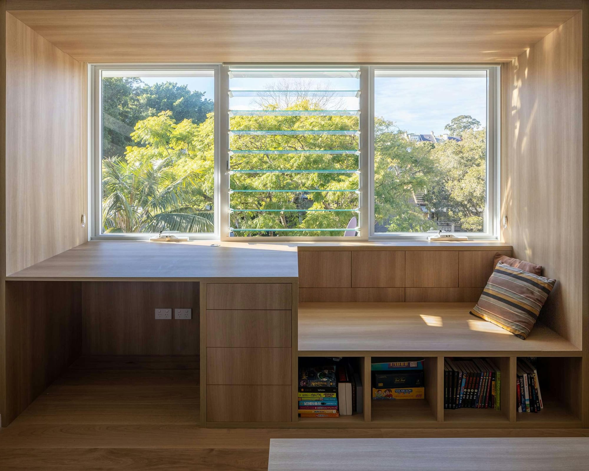 An interior shot of timber joinery in front of a window with a window seat