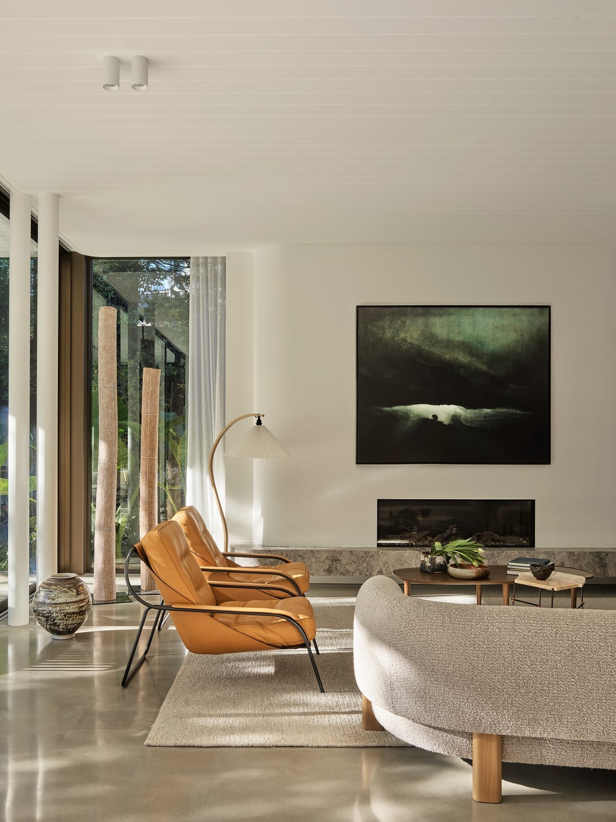 Warren House by CM Studio. Photography by Nic Gossage. Living room with boucle couch and matching leather armchairs. 
