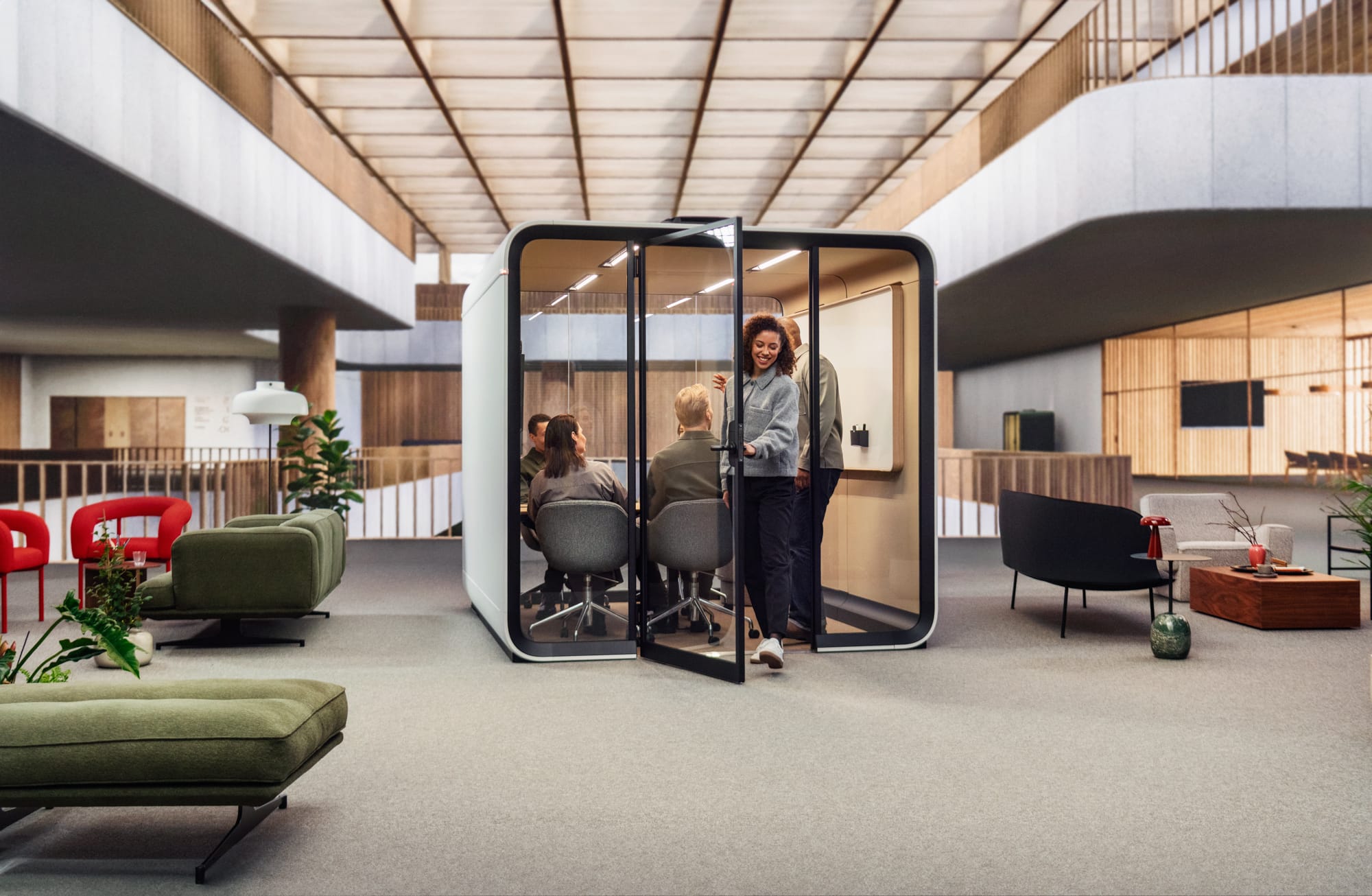 Framery Smart Pod. Copyright of Framery. Woman leaving a white work pod and returning to corporate floor of building. 
